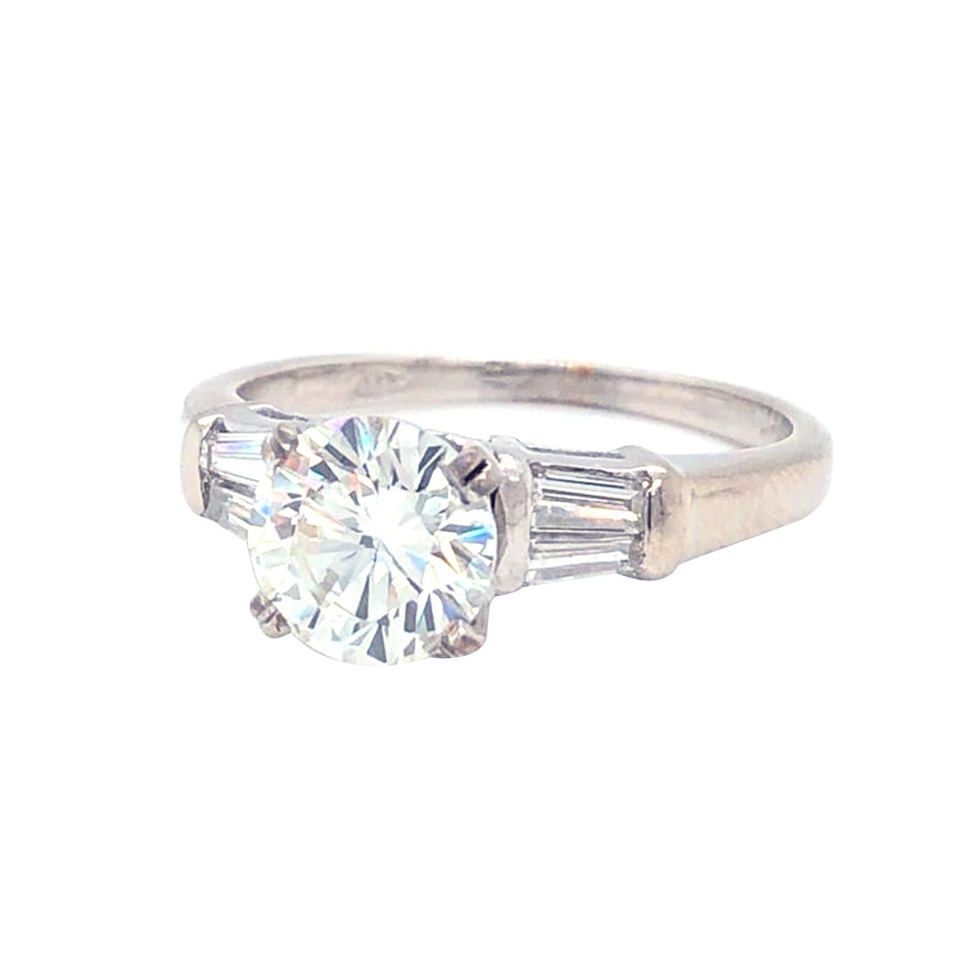 Classic Diamond ring 1.20 Carat center Round Brilliant Certified by Gia as K - Color, VS1  Clarity, and accented by two tapered baguette-cut diamonds, Totaling 0.30 carat H color, VS1 - Clarity, The ring weighs 3.00 grams, and is currently size 6,