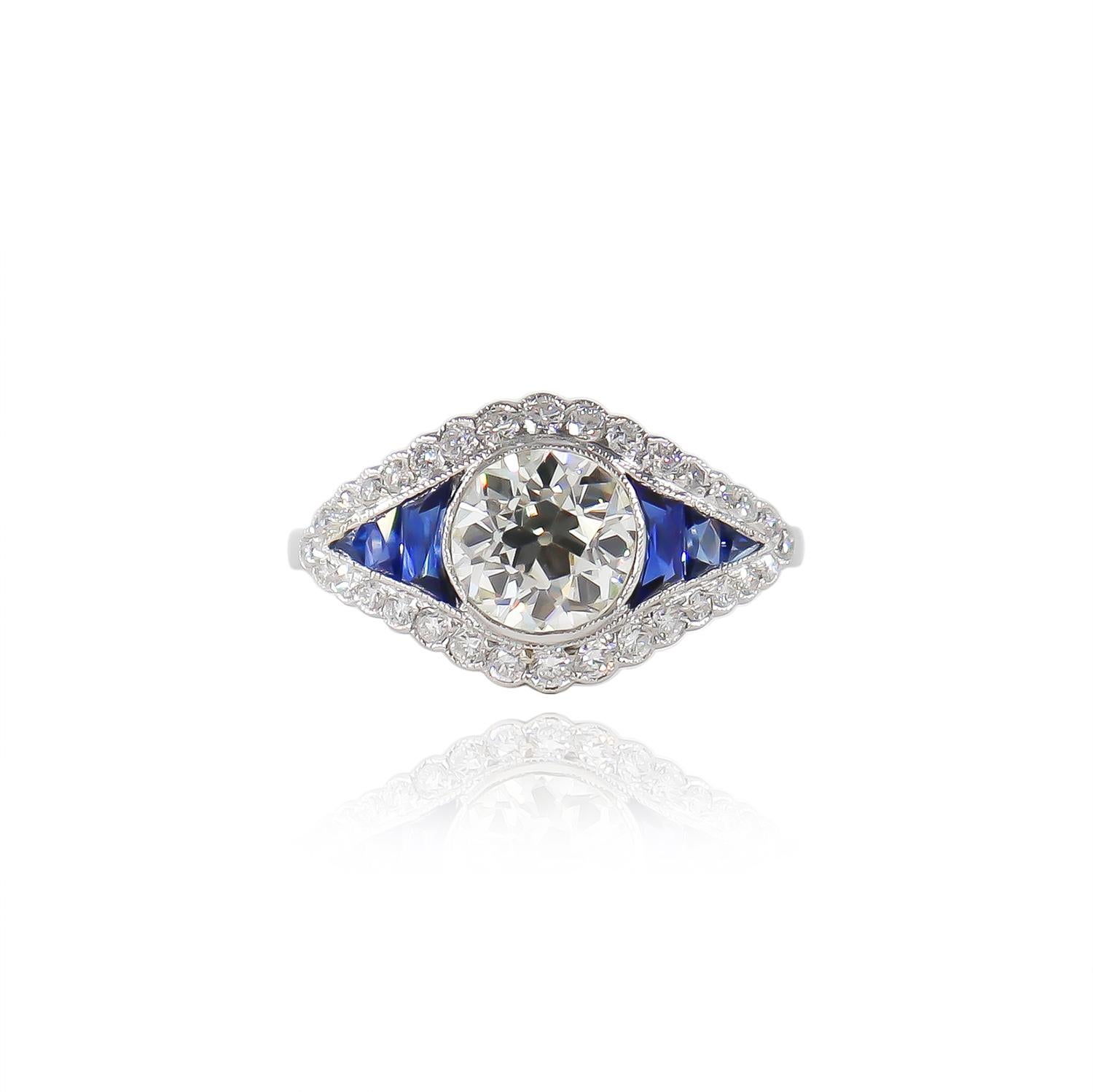 This breathtaking new acquisition by J. Birnbach features a GIA certified 1.21 carat Old European cut diamond of L color and SI1 clarity as described by GIA grading report #6214214288. The center stone is flanked by six, french-cut sapphires and a