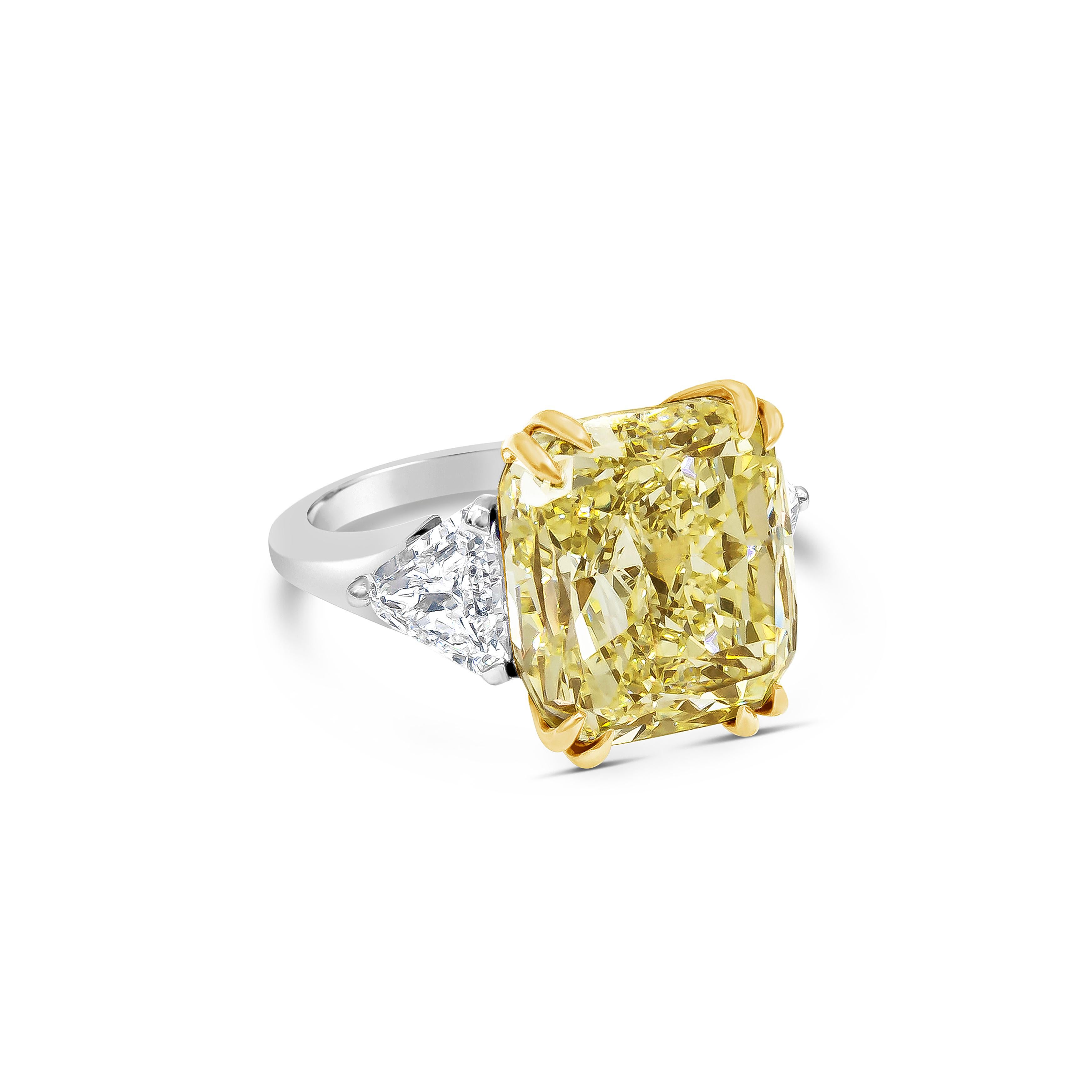 Well crafted high end engagement ring showcasing a GIA certified color-rich fancy light yellow color 12.15 carat cushion cut diamond, VS2 in clarity, set in an eight prong 18k yellow gold basket. Accented with trillion diamonds on each side weighing