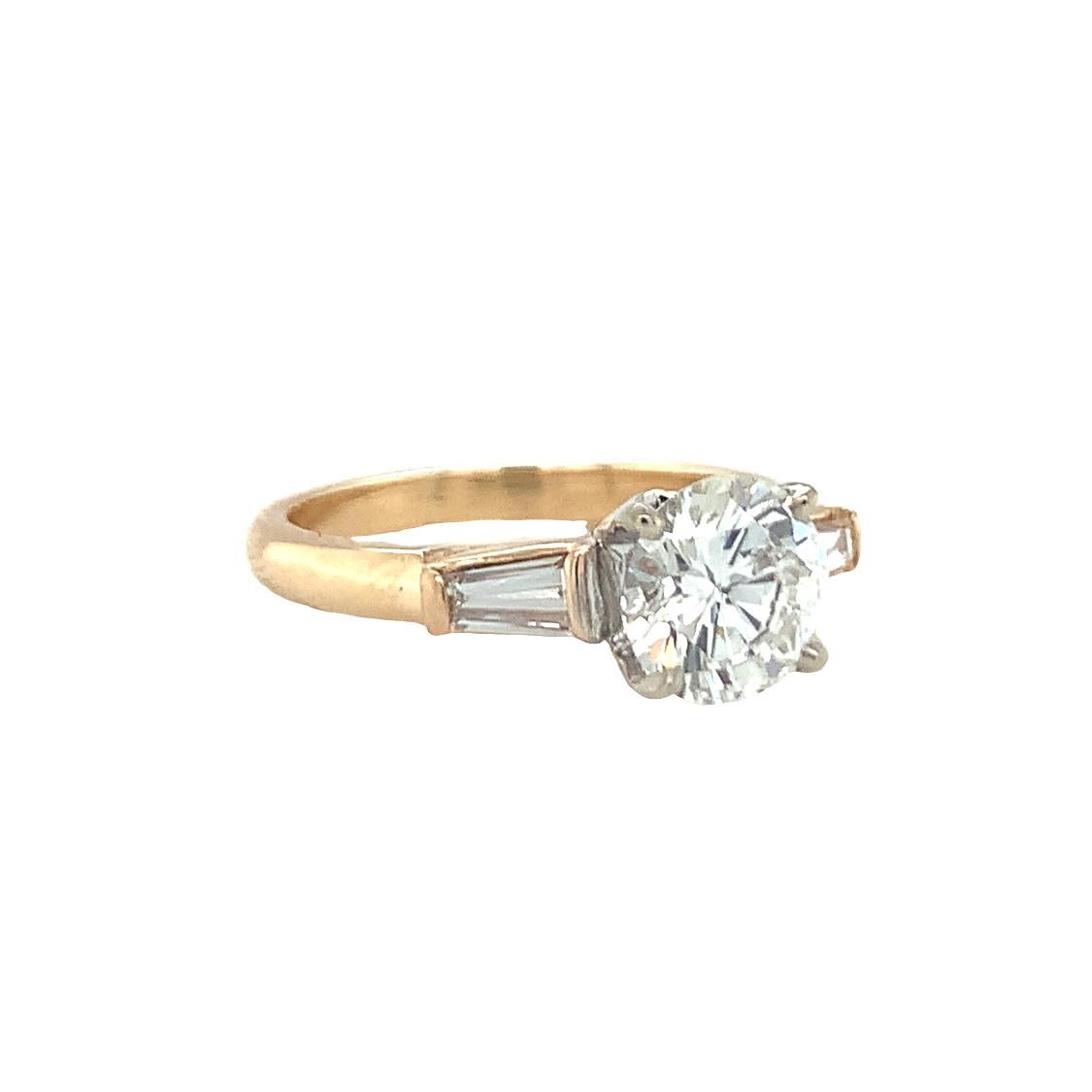 One GIA certified 1.22 ct. round brilliant cut diamond 14K yellow gold engagement ring featuring one diamond weighing 1.22 ct., with H color and SI-1 clarity with GIA cert enhanced by two tapered baguette diamonds weighing 0.20 ct. in total weight,