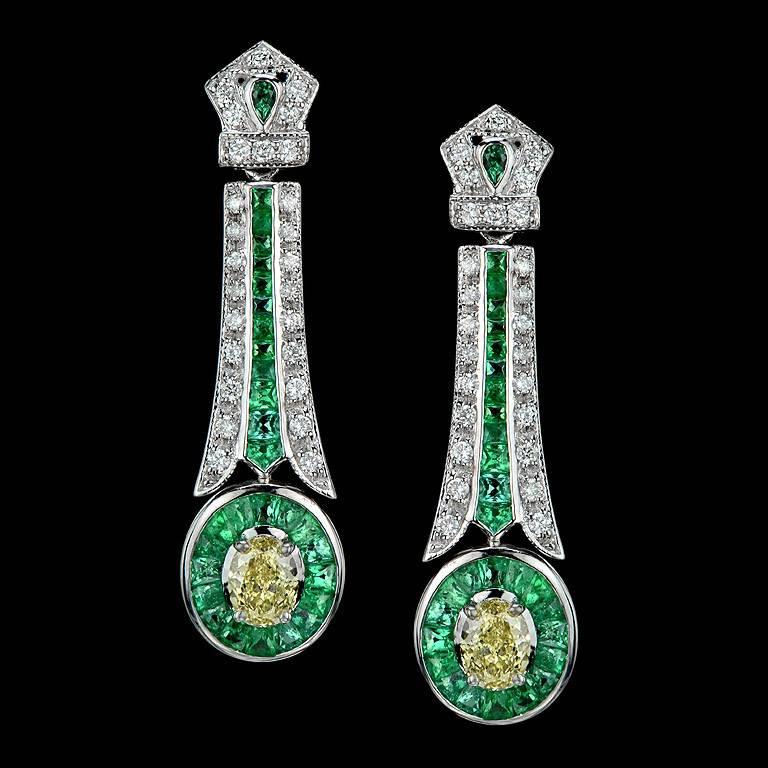 The Exquisite of 18k White Gold Earring, set with GIA Certified Natural Fancy Yellow Oval Shape VS1 Clarity Weight 0.71 Carat and the other one is VS1 Clarity  Weight 0.51 Carat. 

The Earring surrounded by French Cut Emerald 58 pieces 4.60 Carat