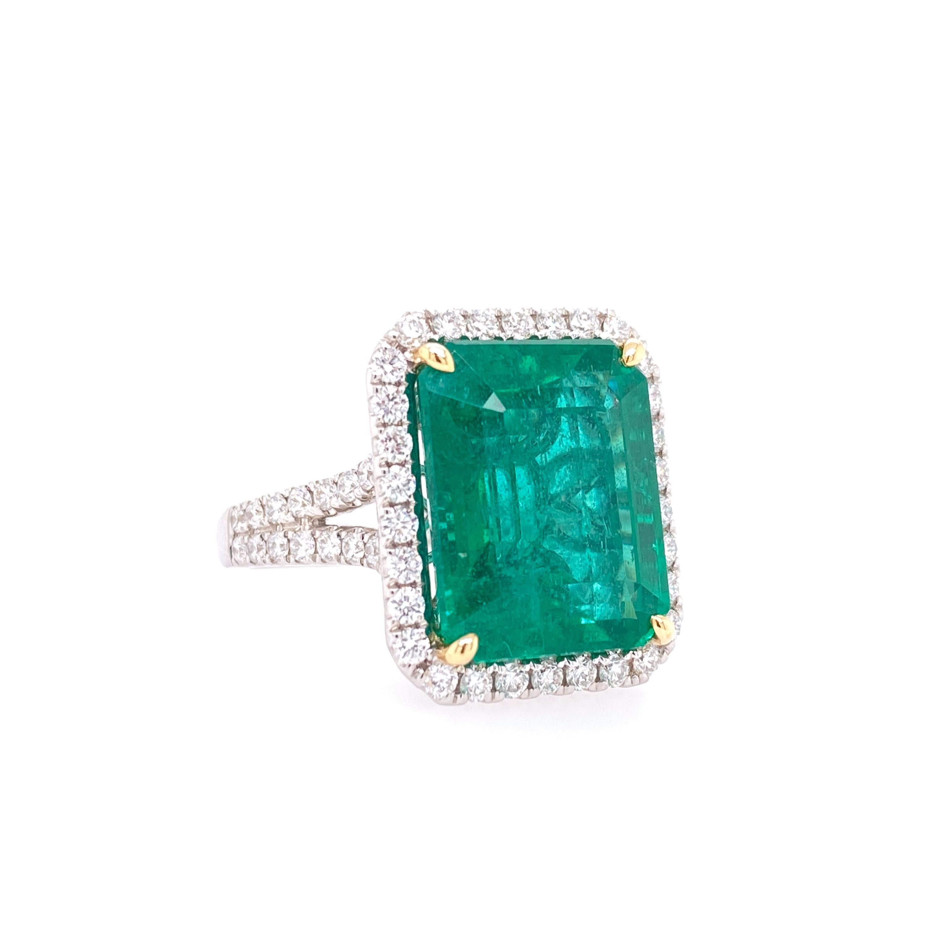 This stunning Cocktail Ring features a beautiful GIA Certified 12.25 Carat Emerald Cut African Emerald with a Diamond Halo, that sits on a Double Diamond Shank. This Ring is set in 18K White Gold, with 18K Yellow Gold prongs on the center