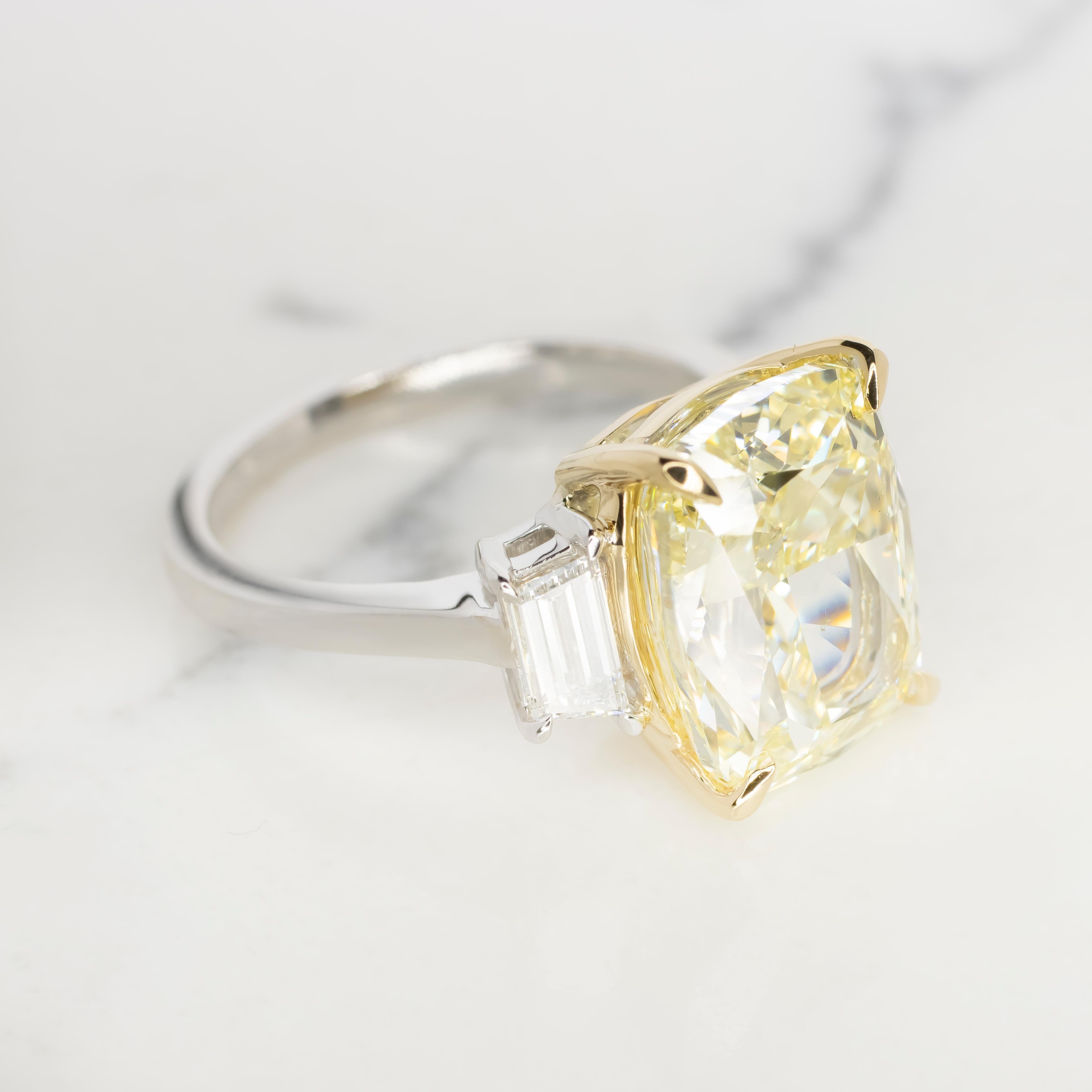 Voici l'époustouflante bague en diamant certifié GIA de 12,34 carats de couleur jaune clair fantaisie, taille coussin, un véritable symbole de luxe et d'élégance. En son centre éblouit un magnifique diamant de taille coussin, certifié par le très