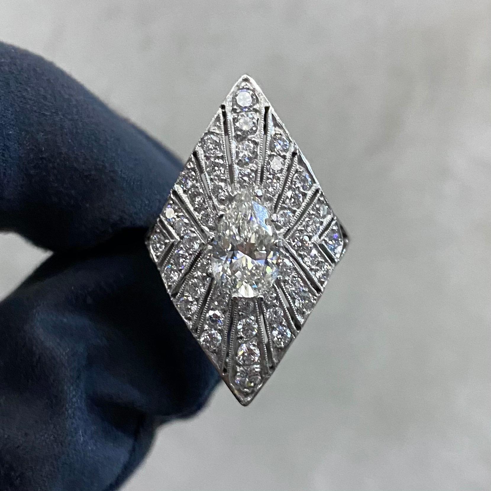 A GIA certified 1.24 carat J VS2 pear brilliant-cut diamond and round brilliant-cut diamond shield-shape cocktail or dress ring in platinum, circa 2000s. A spectacular jewel of an Art Deco style shield design with pierced openwork and millegrain