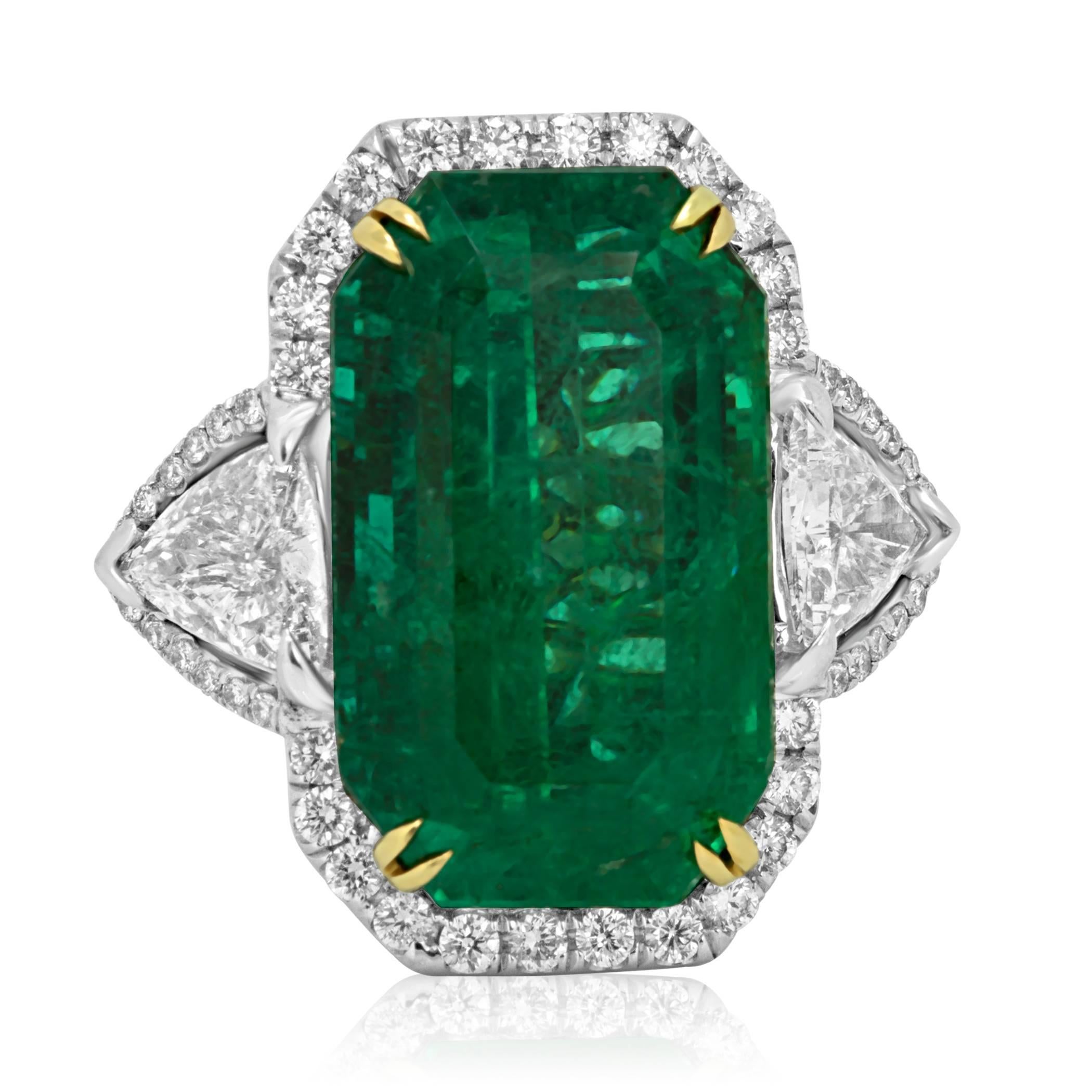 Stunning One of a kind GIA certified 12.40 Carat Emerald cut Zambian Emerald Flanked with 2 White diamond Trillions 1.04 Carat Encircled in a Single Halo of White Diamond Rounds 0.66 Carat in Hand Made 18K White and Yellow Gold Cocktail Ring.

MADE