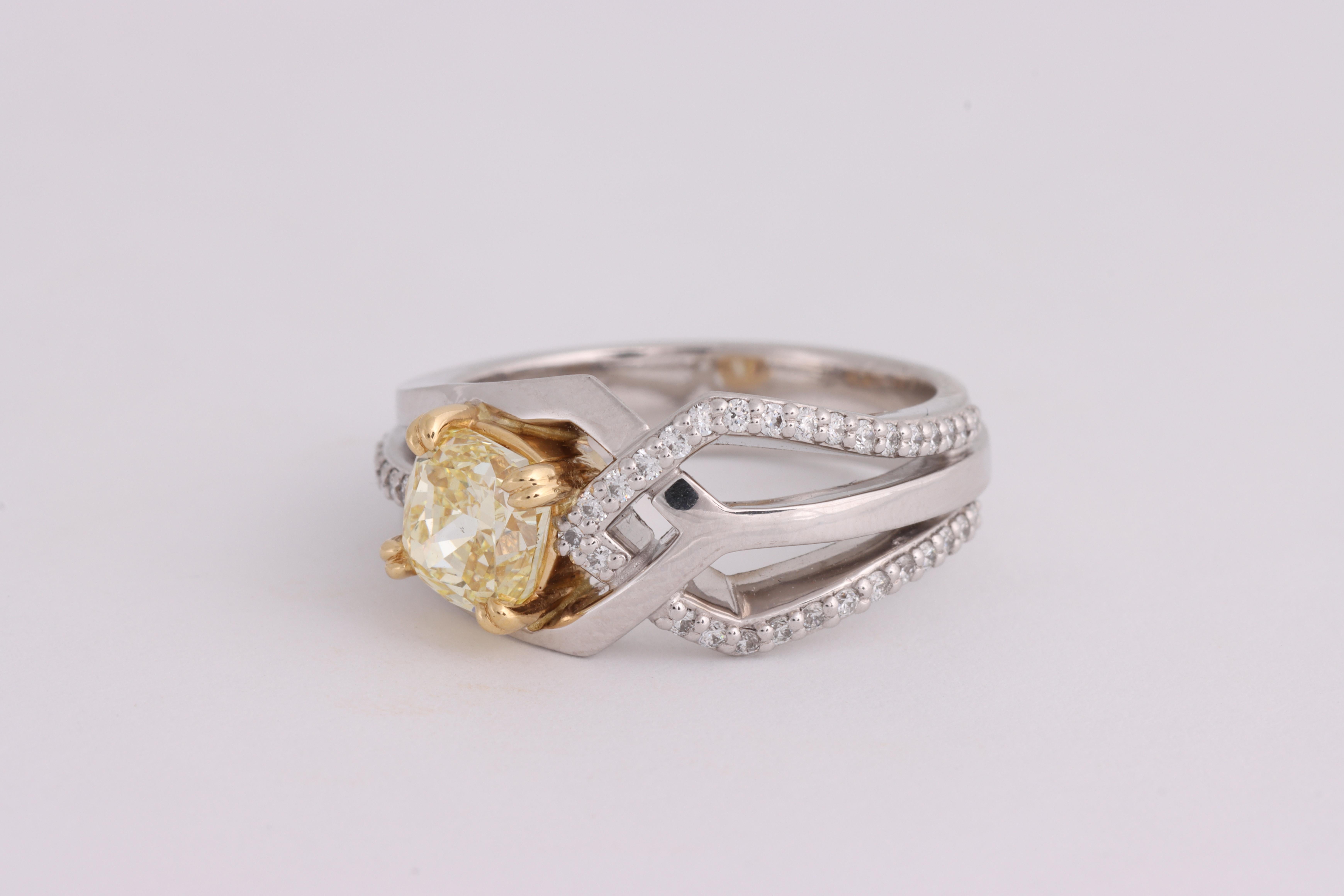 18 karat white gold pave set yellow gold claw set ring featuring on GIA Certified Cushion Cut Fancy Light Yellow diamond of Vs2 clarity and weighing 1.24ct.  Total ring weight 8.93 grams.  Stamped 750.