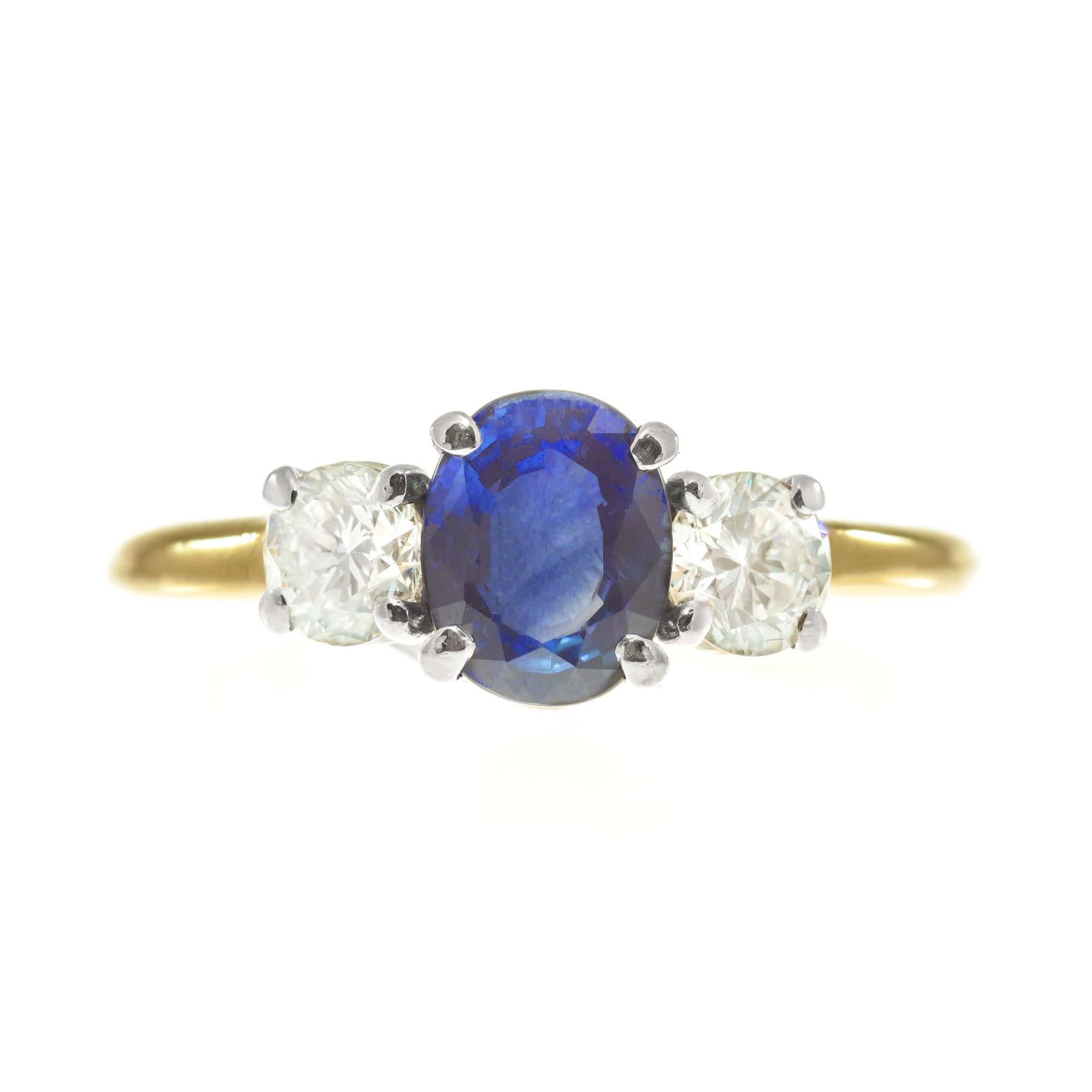 Bright blue color 1.25 carat oval sapphire and diamond three-stone engagement ring. Oval center sapphire with two round brilliant cut accent diamonds in a platinum and 18k yellow gold setting. GIA certified. 

1 oval blue SI sapphire  Approx. Total