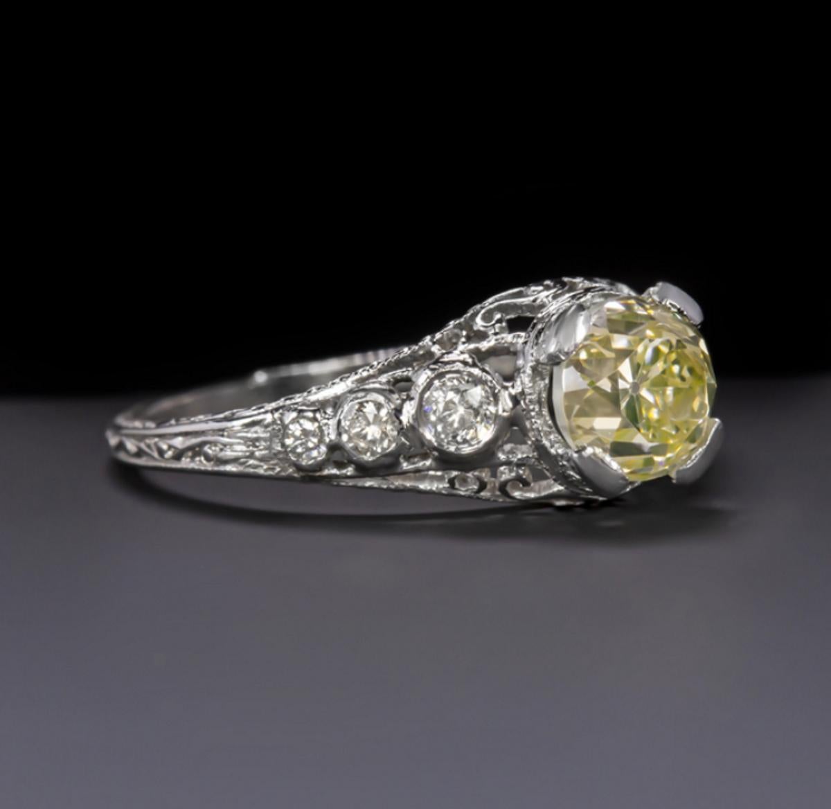 This romantic and timelessly designed original vintage ring showcases a lively and completely eye clean old European cut diamond in an intricate diamond studded platinum setting. The 1.09ct GIA certified diamond has a cheery bright yellow hue and