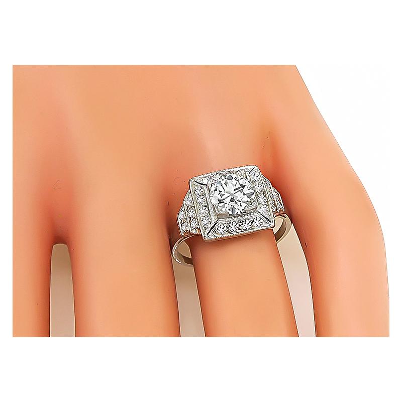 This is an amazing platinum engagement ring from the Art Deco era. The ring is centered with a sparkling GIA certified old European cut diamond that weighs 1.25ct. The color of the diamond is K with SI2 clarity. The center diamond is accentuated by