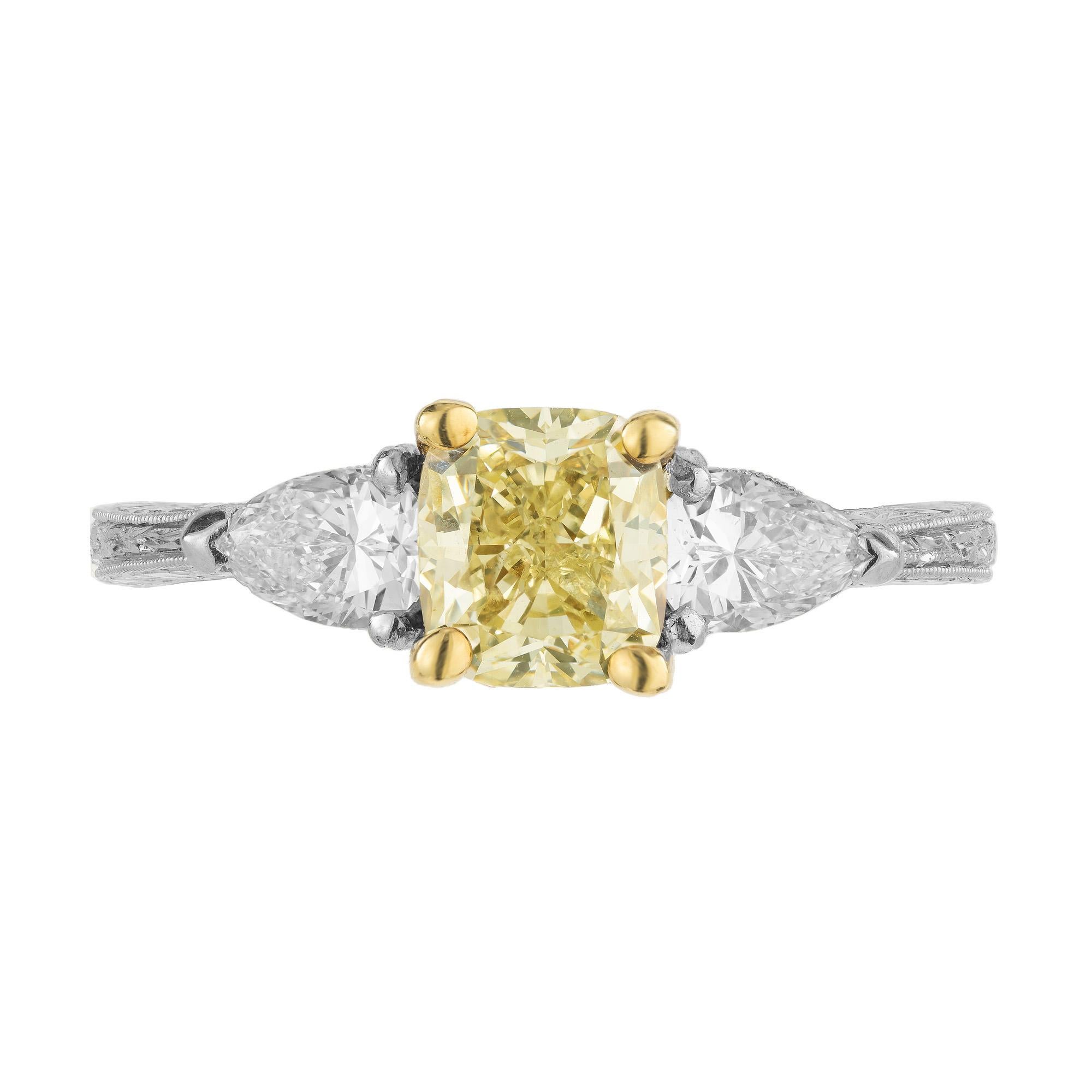 Carefully crafted three-stone diamond engagement ring with a 1.26 carat GIA certified gorgeous fancy light yellow radiant cut diamond center stone, flanked by two white pear shaped diamonds in a beautiful hand engraved platinum and 18k yellow gold,