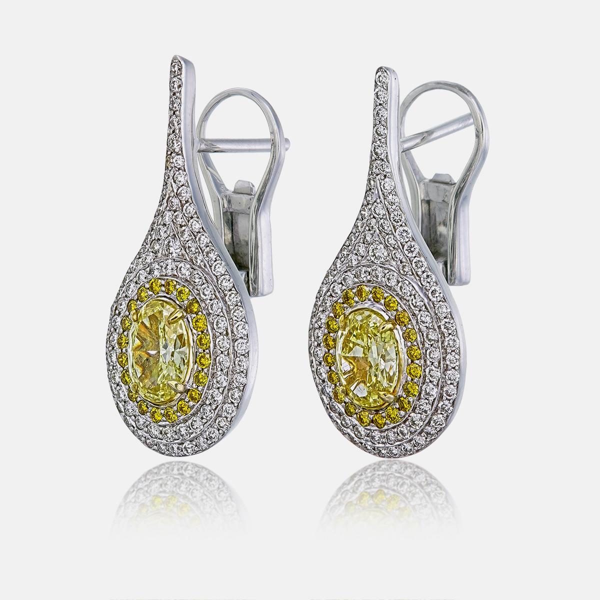 Ti presentiamo un raffinato paio di orecchini con diamanti centrali Fancy Intense Yellow (FIY) VS1 certificati GIA, del peso di 0,62 e 0,67 carati ciascuno (numeri di certificato GIA: 5221362201 e 2225362191). Questi diamanti vibranti aggiungono un