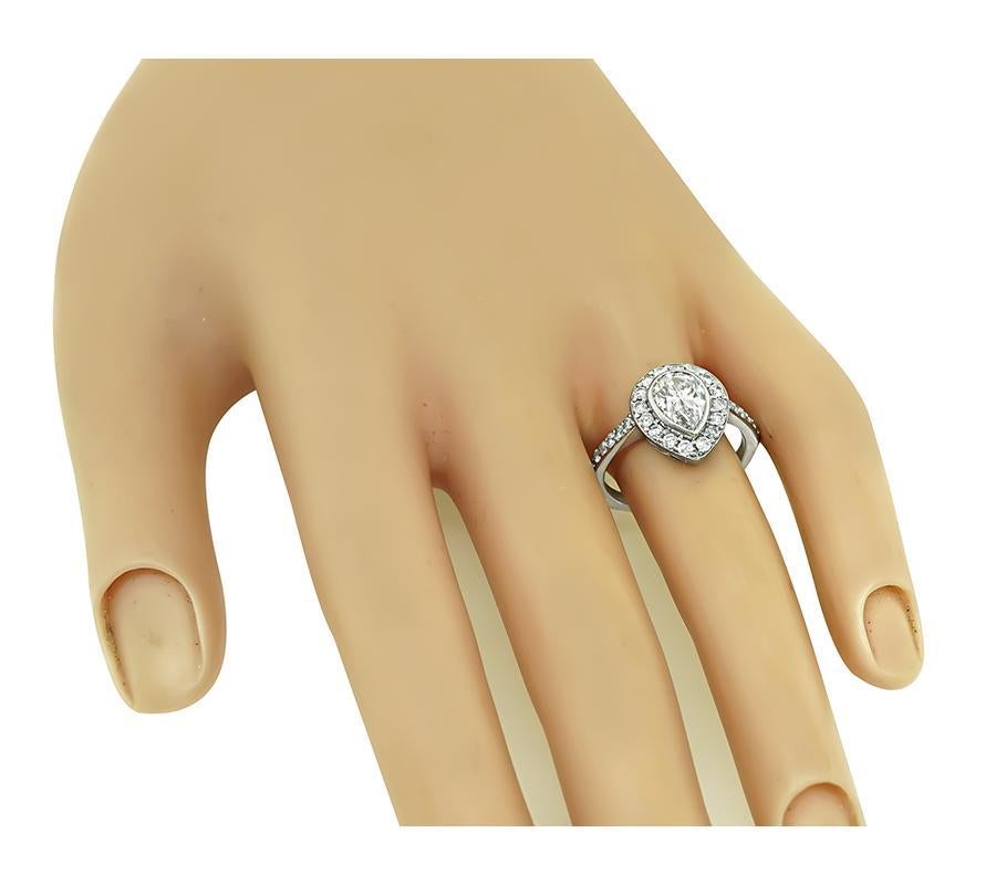 This is a charming 18k white gold engagement ring. The ring is centered with sparkling GIA certified pear shape diamond that weighs 1.29ct. The color of the diamond is F with SI2 clarity. The center diamond is accentuated by dazzling round cut