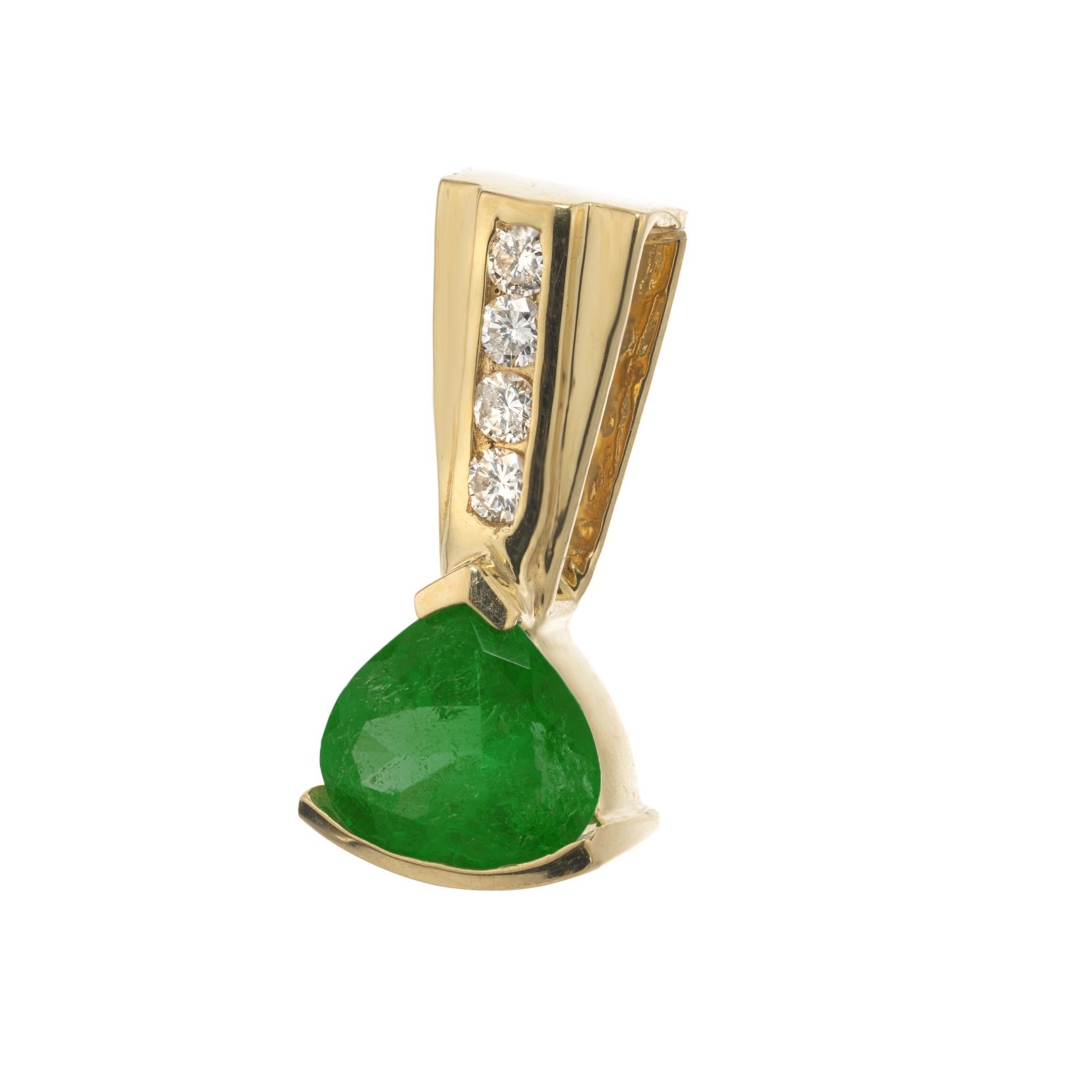 GIA Certified 1.30 bright green emerald diamond pendant in 18k yellow gold. This stunning pendant features a modified heart shaped emerald, accented by 4 round brilliant cut diamonds in 18k yellow gold. Certified by the GIA, ensuring unparalleled