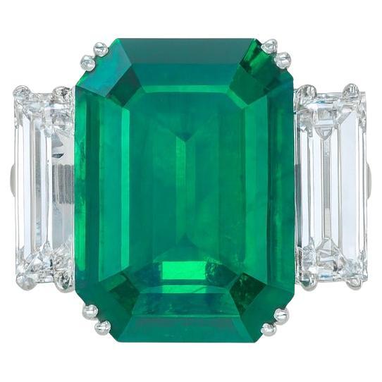 GIA Certified 13.20 Carat Emerald and Diamond Platinum Ring

A magnificent statement piece showcasing a GIA certified 13.20 carat octagonal step-cut emerald, transparent and vividly green, enhanced for clarity (F1). The emerald is beautifully framed