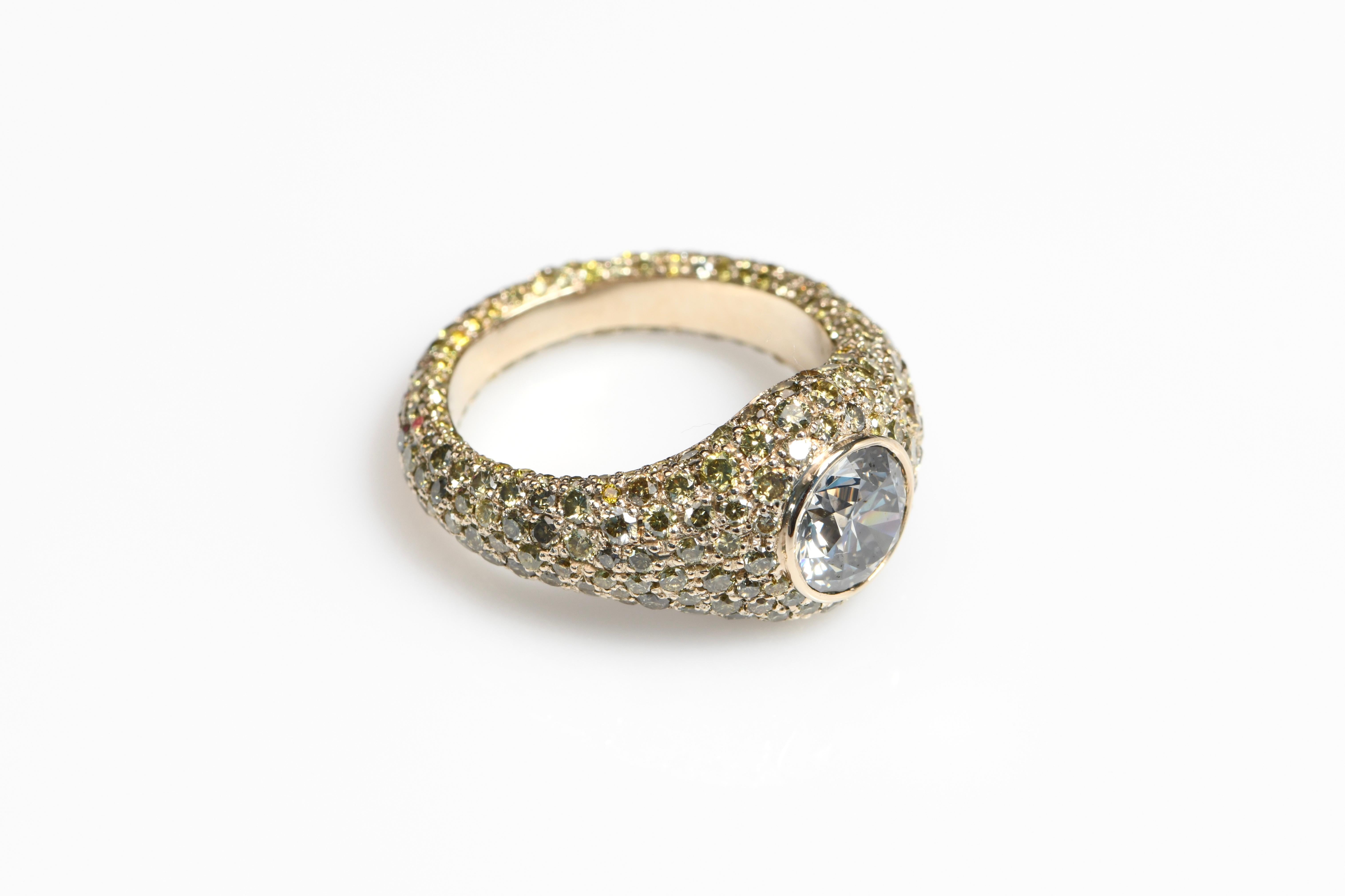Questo straordinario anello presenta un diamante rotondo VS2 certificato GIA di colore grigio scuro, incastonato in un castone per un look audace ma elegante. L'incastonatura in oro bianco 18 carati è impreziosita da oltre 3 carati di diamanti melee