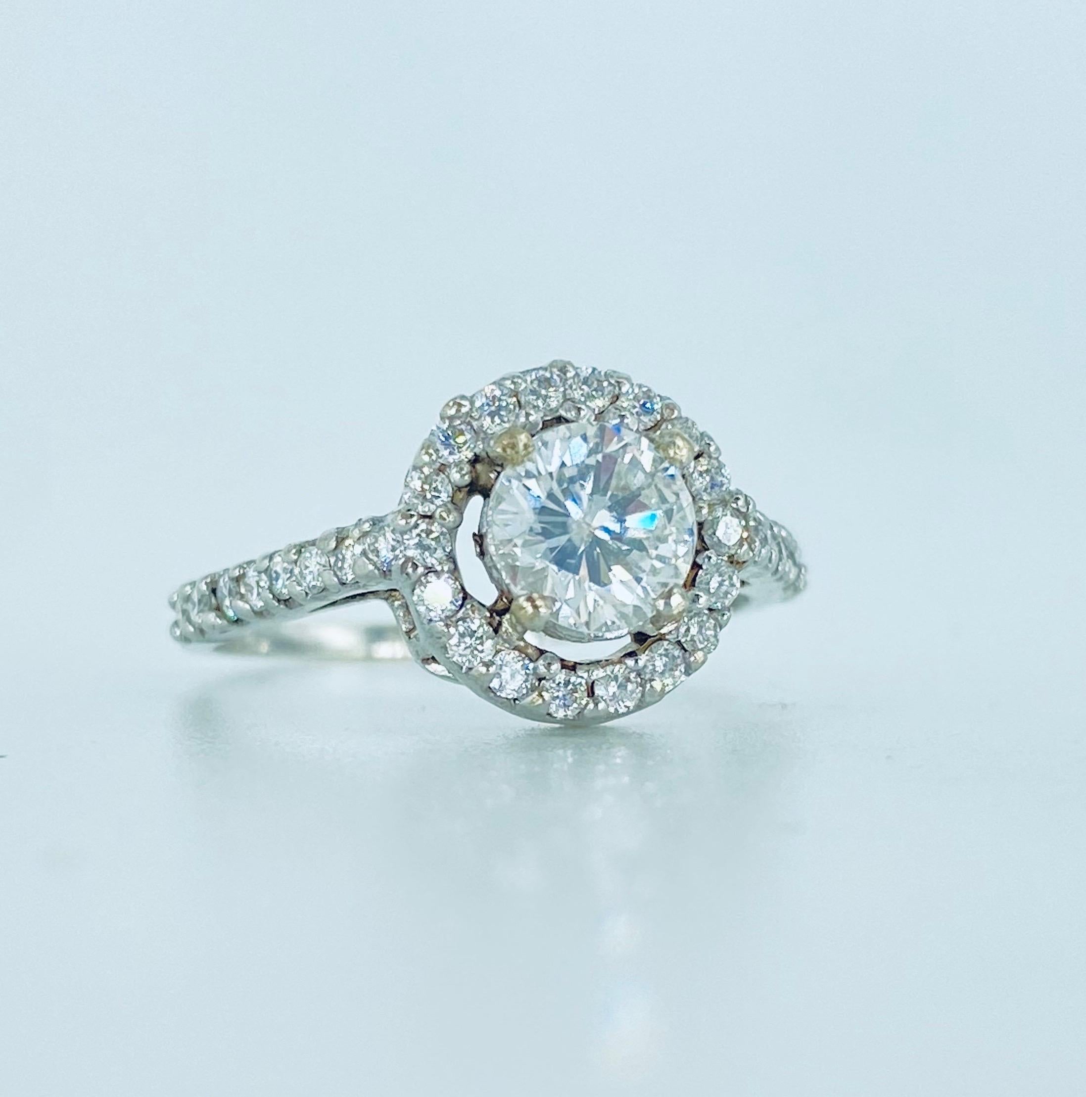 Bague de fiançailles Halo en or blanc 18k certifiée par le GIA avec 1,34 carat de diamants. Le diamant central est certifié GIA et pèse 0,66 carat E/I2. Il est entouré d'environ 0,68 carat de diamants ronds. L'anneau pèse 2,4 grammes et est fabriqué