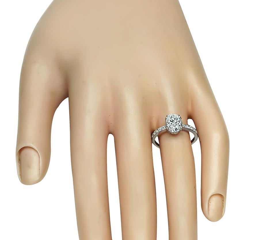 Voici une magnifique bague de fiançailles en platine. La bague est ornée d'un diamant de taille ovale étincelant, certifié par la GIA, qui pèse 1.36 ct. La couleur du diamant est G et sa pureté SI1. Le diamant central est rehaussé par d'éblouissants