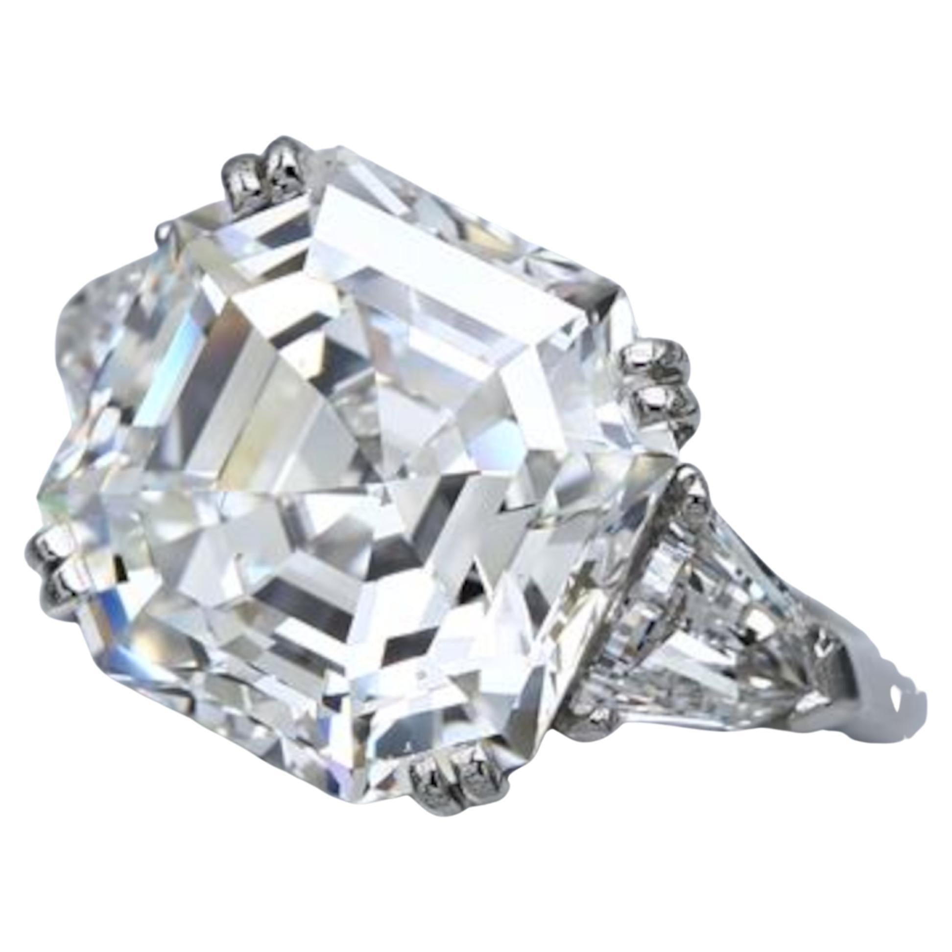 GIA Certified 13.84 Ct. Asscher Cut Diamond Ring, elegantly set in luxurious platinum. This stunning piece features two beautiful diamonds enhancing the ring's brilliance and sophistication. Perfect for engagements or special occasions, this ring