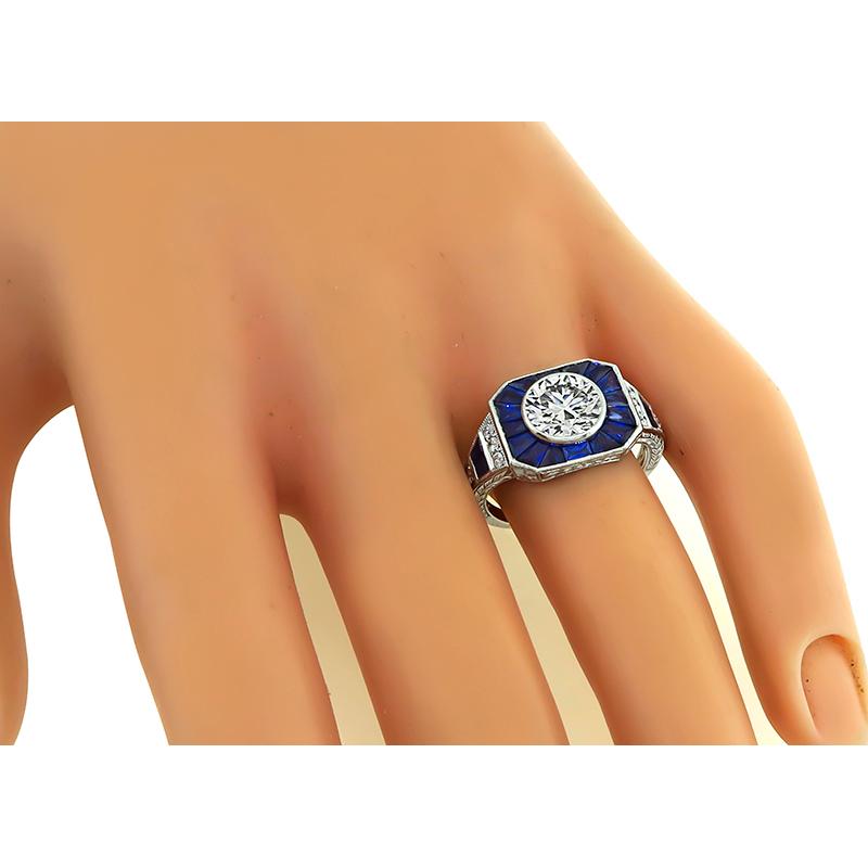 Este es un magnífico anillo de compromiso de platino de Sophia D. El anillo está centrado con un brillante diamante de talla europea antigua certificado por el GIA que pesa 1,38 ct. El color del diamante es M con claridad VVS2. El diamante está