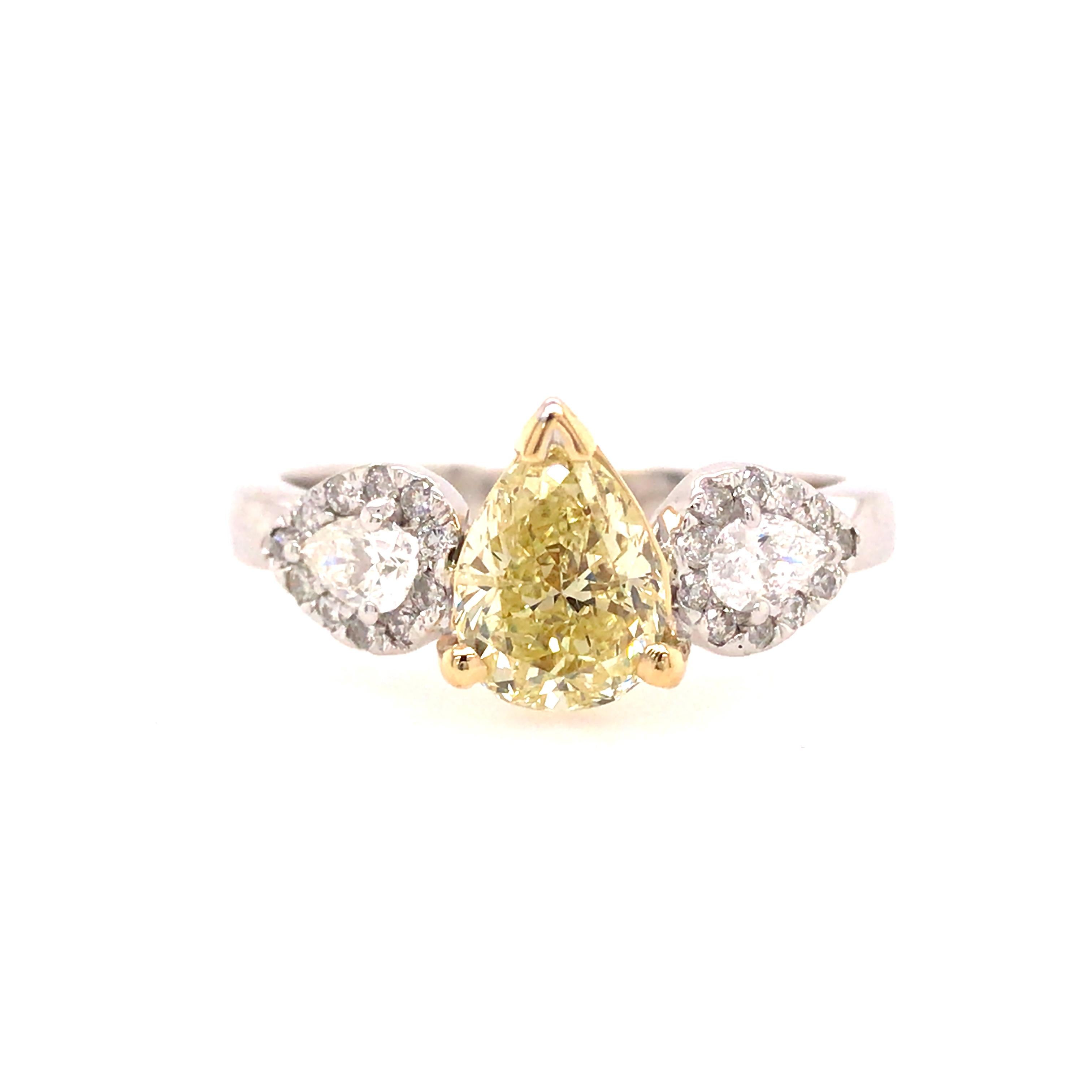GIA Certified 1.39 Carat Fancy Yellow Pear Shape Diamond 3-Stone Ring in 18K Two-Tone Gold.  The Fancy Yellow Pear Shape Center, I1 in clarity is set between (2) Halo surrounded Pear Shape Diamonds weighing 0.65 carat total weight, G-H in color and