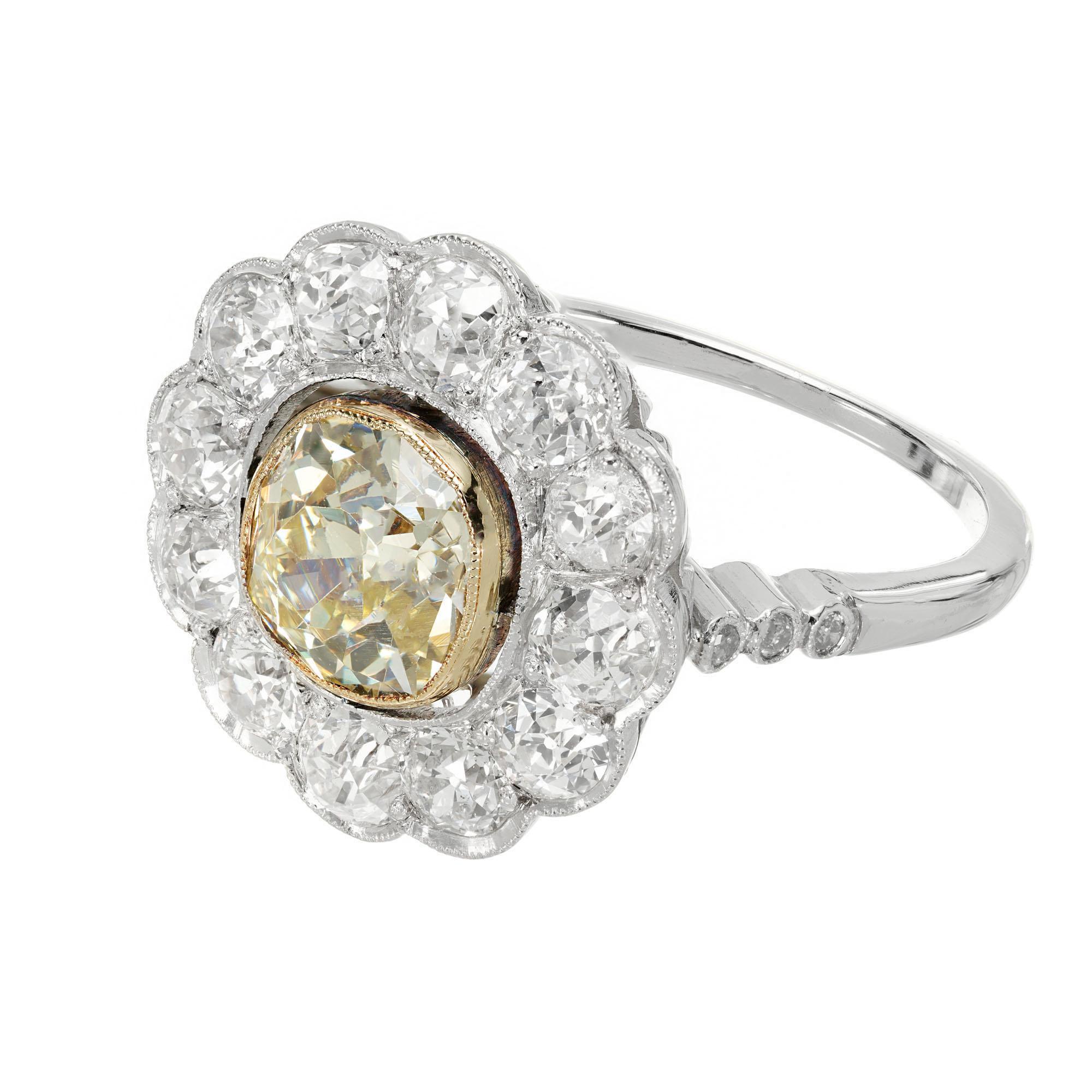  1900's yellow and white diamond halo engagement ring. GIA 1.39ct bezel set old mine brilliant cut fancy yellow diamond center stone with a halo of  12 round old mine cut diamonds in a platinum setting with 6 side diamonds.

1 old mine brilliant cut