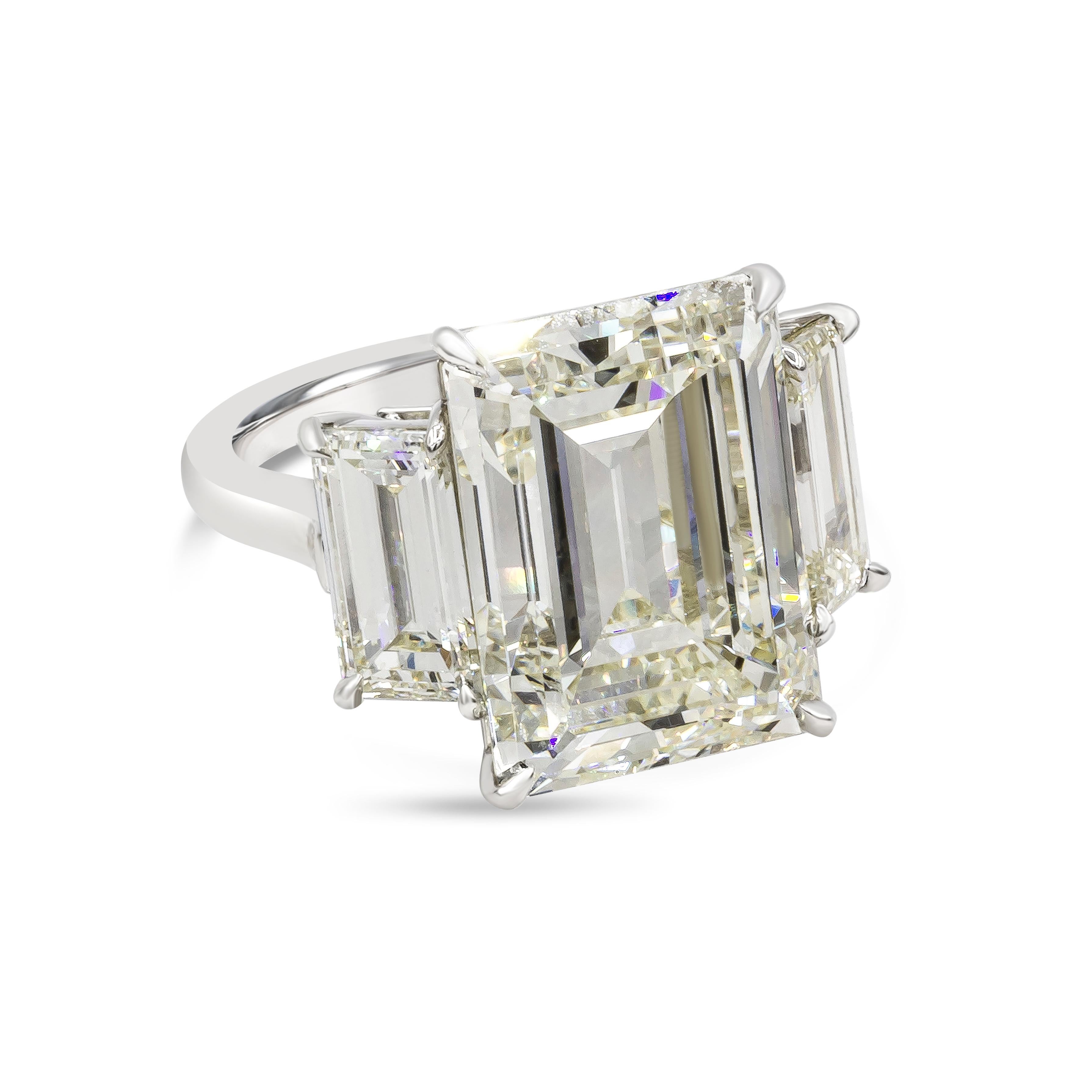 A rare and spectacular engagement ring showcasing a 14.18 carat emerald cut diamond center stone certified by GIA as M color, VVS2 clarity. Flanked by baguette diamond on each side weighing 3.81 carats total, M color, VS in clarity. Finely made in