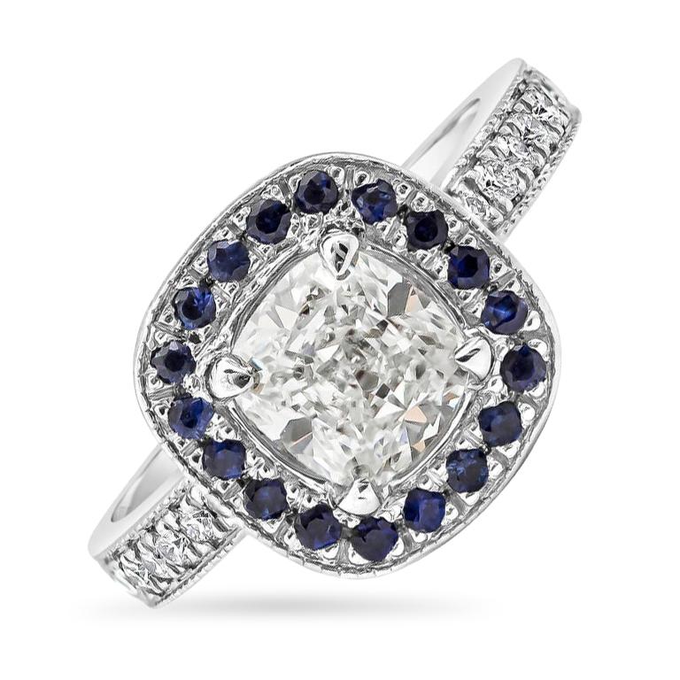 Showcases a 1.42 carats cushion cut diamond center stone that GIA certified as G color and SI2 in clarity, safely set in four prong setting. Surrounded by a single row of round blue sapphires weighing 0.35 carats total, set in an antique-style