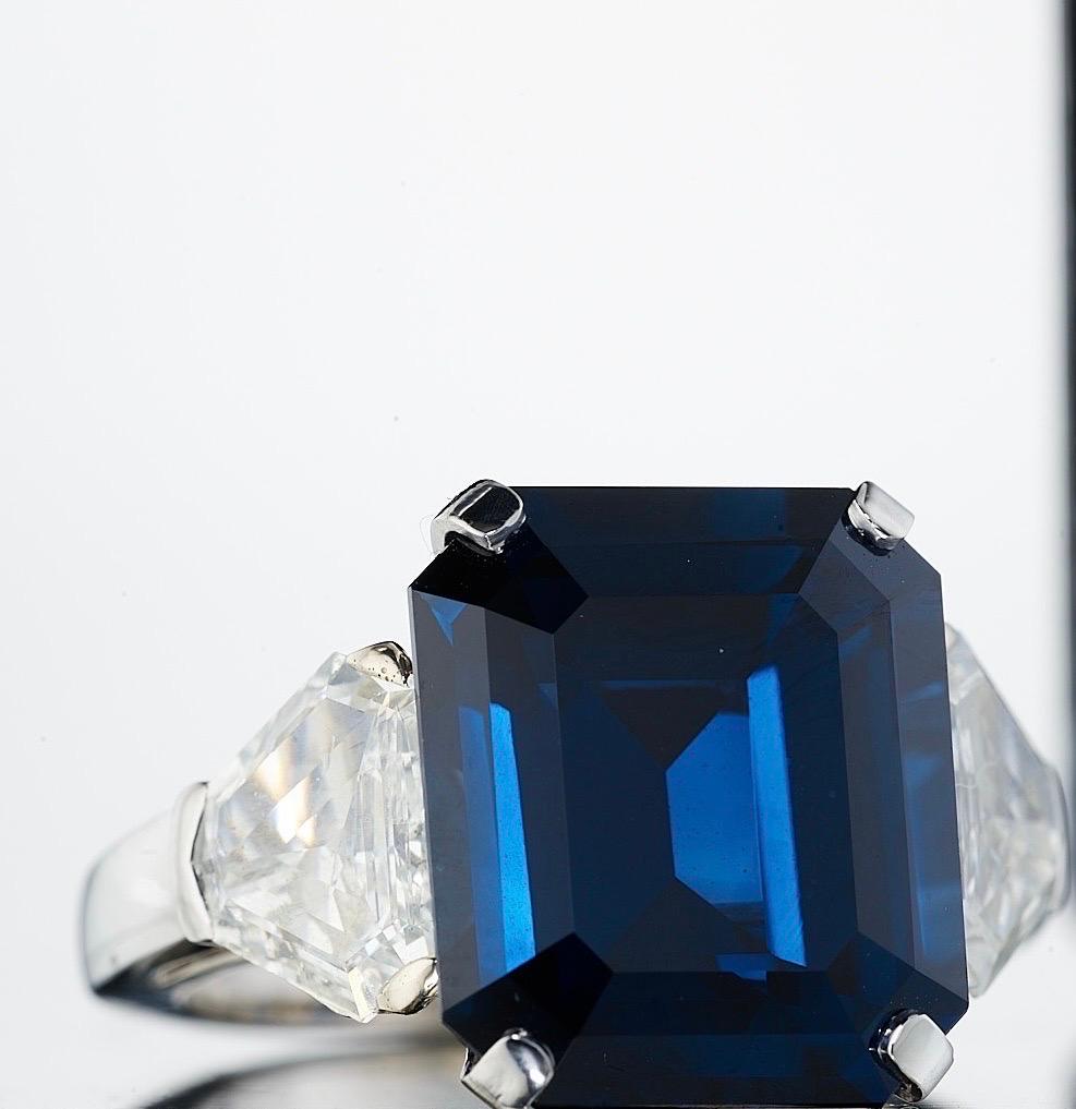 Featuring a magnificent Emerald Cut Sapphire weighing 14.24 Carats, flanked by shield cut diamonds weighing approximately 2.30 carats.

This particular Sapphire is unique for its rich blue color and its cutting style. Truly one of a kind!

Set in