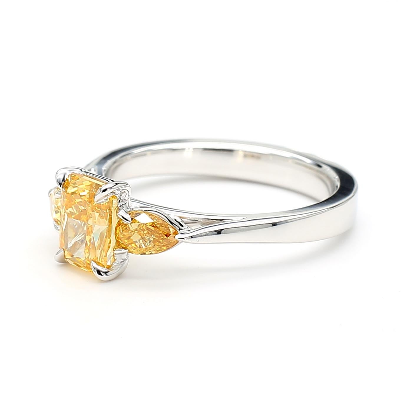 Cette bague à trois pierres en diamant orange-jaune témoigne d'un travail artisanal de qualité et d'un design intemporel. Parfaite pour ceux qui apprécient la beauté des diamants naturels, cette bague offre un équilibre entre luxe et simplicité de