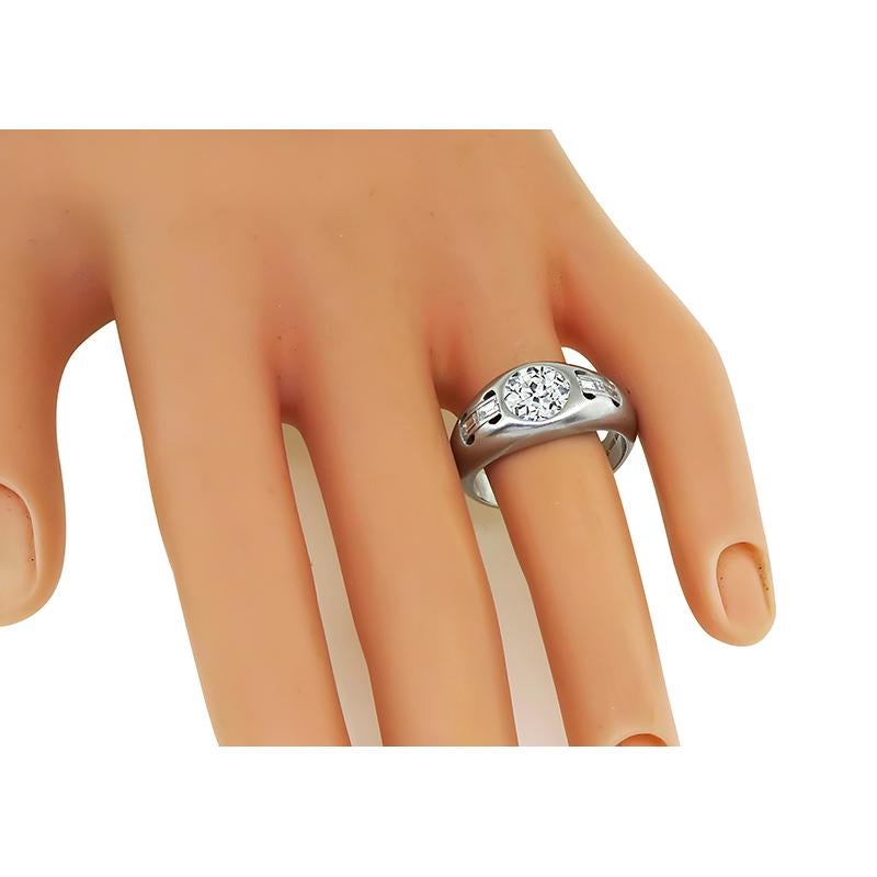 This is a fabulous platinum men's ring. The ring is centered with a sparkling GIA certified old European cut diamond that weighs 1.47ct. The color of the diamond is K with VS2 clarity. The center diamond is accentuated by dazzling baguette cut