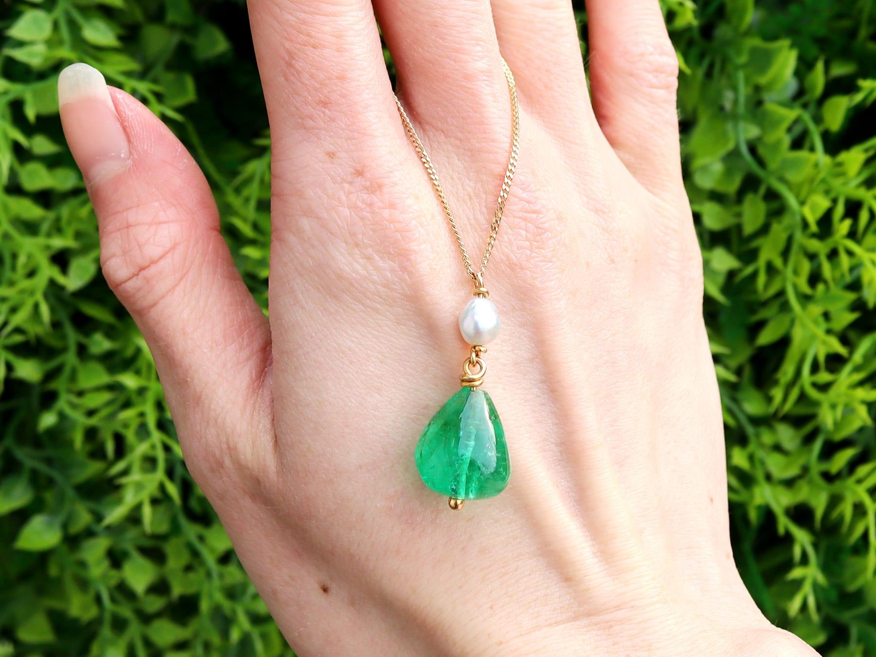 A stunning, fine and impressive vintage 14.80 carat Colombian emerald and pearl, 18 karat yellow gold pendant; an addition to our vintage jewelry collections.

This stunning vintage emerald pendant has been crafted in 18k yellow gold.

The