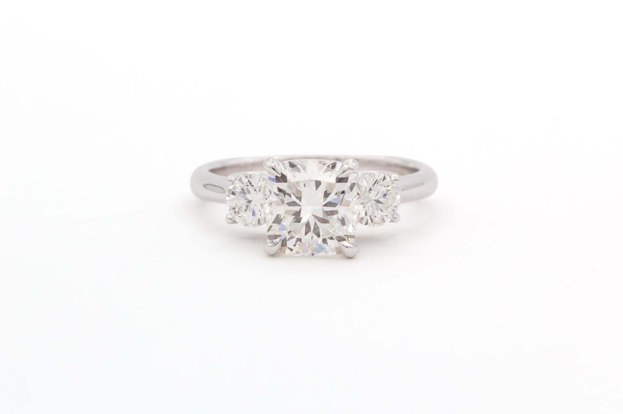 Wir freuen uns, diese GIA zertifiziert & Laser beschriftet 14k Weißgold & Diamant Drei Stein Verlobungsring anzubieten. Dieser wunderschöne Ring besteht aus einem GIA-zertifizierten Diamanten im Kissenschliff mit einem Gewicht von 2,04ct I/SI1, der