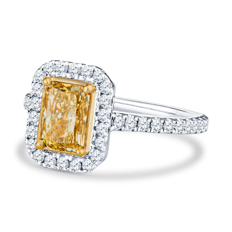 This beautiful engagement ring features a natural fancy brownish yellow 1.50 carat radiant cut natural diamond bezel set in 14 karat yellow gold. It is accented by 0.74 carat total weight in round diamonds set in 14 karat white gold. This ring is