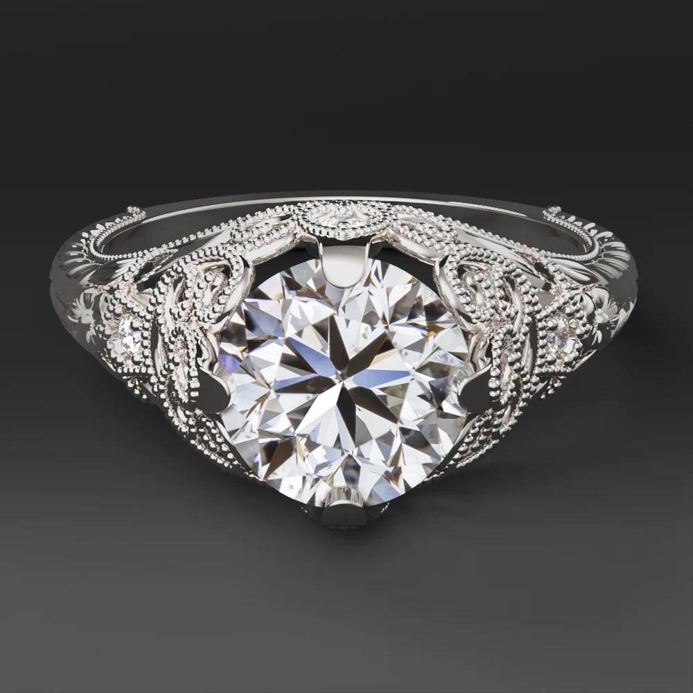 This vintage style diamond ring offers bright sparkle and a romantic design with swirling filigree, botanical engraving, and milgrain details. The center Diamond is a substantial 1.50 carat round brilliant Cut.
The main diamond is certified by the