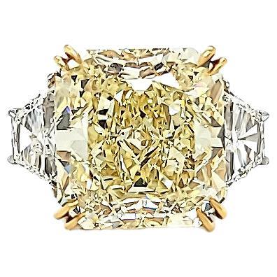 Center stone is a Radiant cut Diamond weighing 15.06 carats GIA certified Fancy Yellow SI1 clarity. Set in a hand made platinum and 18k Yellow Gold setting with 2 Brilliant Cut Trapezoid weighing 1.42 carats total. The trapezoids are VS1 clarity and