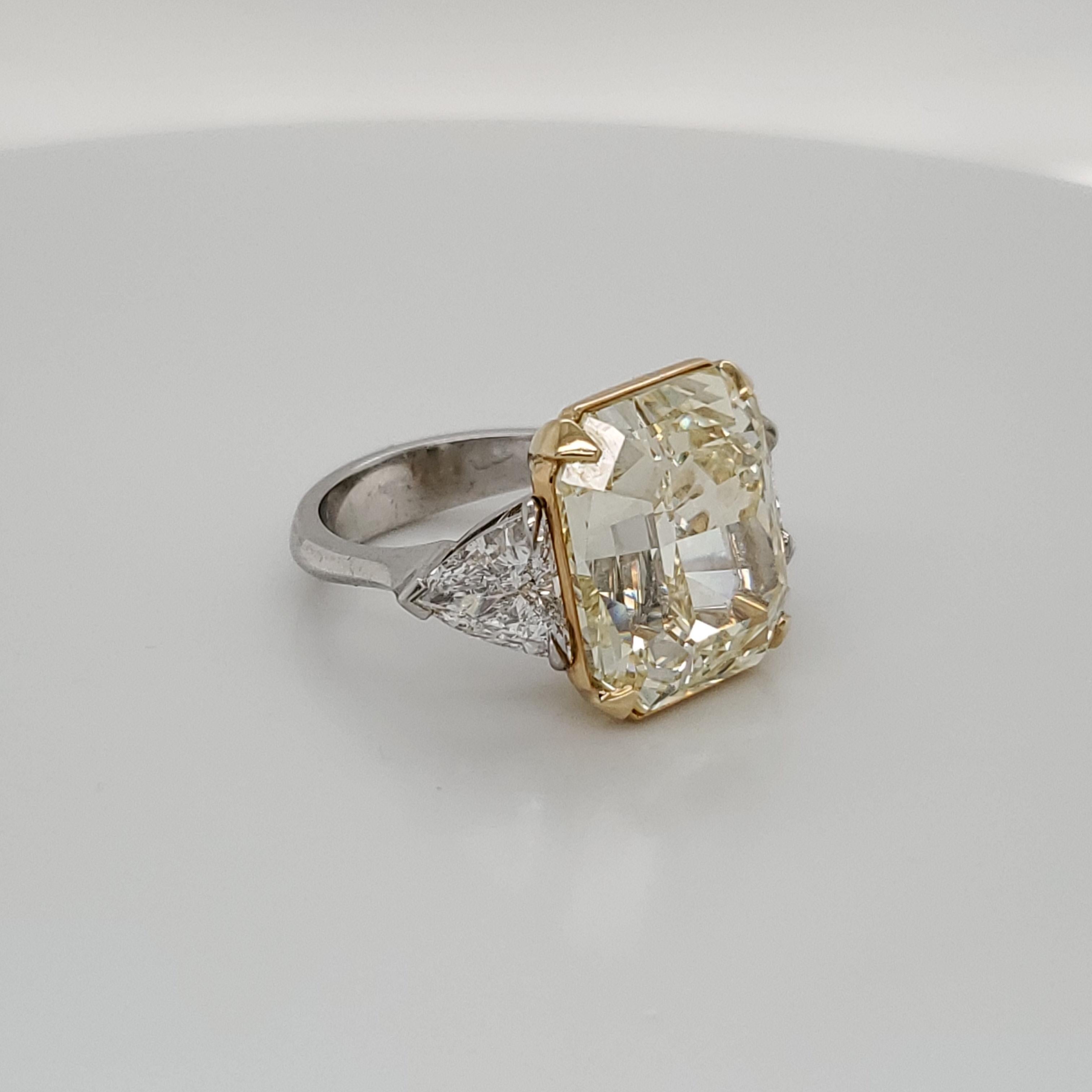 GIA Certified 15.07 Fancy Yellow VS1 center diamond set in Platinum and 18k yellow gold with 2 trillion shaped diamonds weighing about 1.98 carats total 