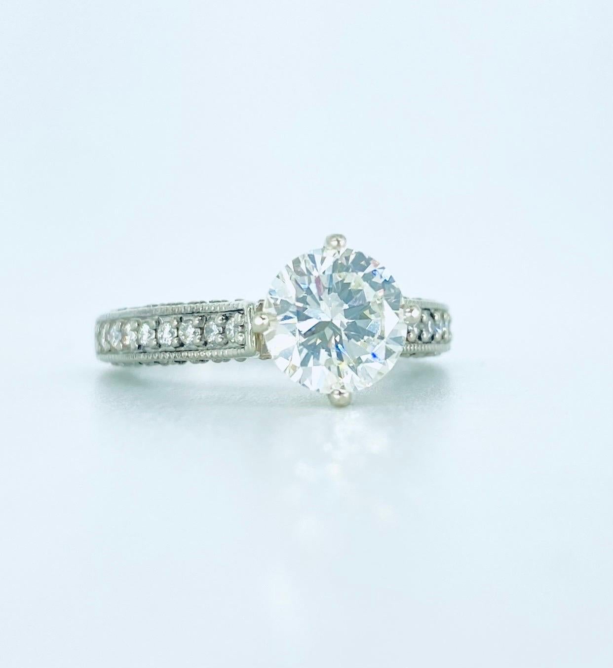 Bague de fiançailles avec diamant central certifié GIA de 1,51 carat 
Le diamant est classé : 
Couleur : K.
Clarté : SI1
Diamant central : 1,51 carat
Forme : Rond
Magnifique bague en diamant avec des pierres latérales pesant environ 0,64 carat pour