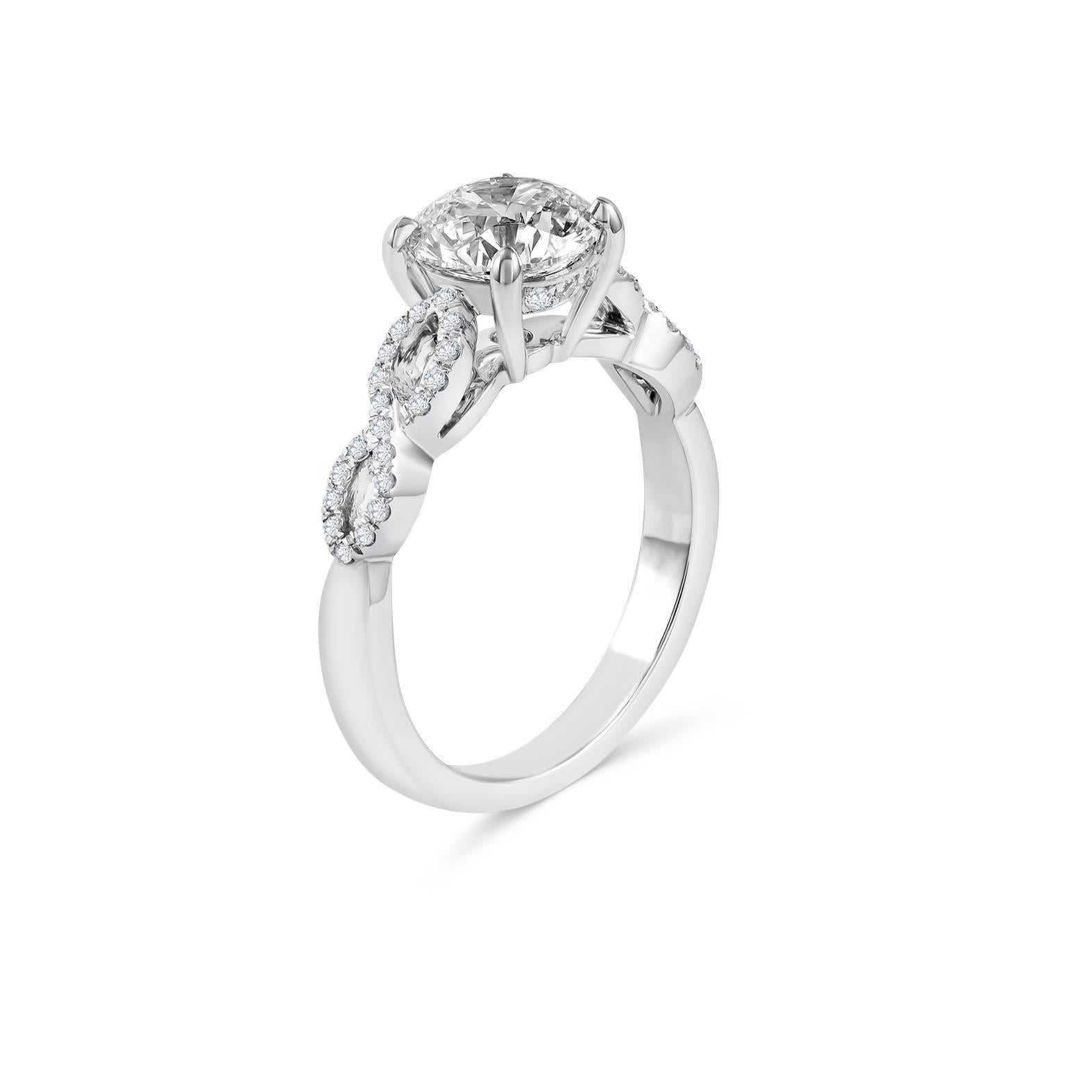 A stylish engagement ring, featuring a 1.51 carats round brilliant cut diamond certified by GIA as F color and VS2 clarity, set on a four prong basket. Accented by 46 round brilliant cut diamonds weighing 0.20 carat total, set on an intertwined