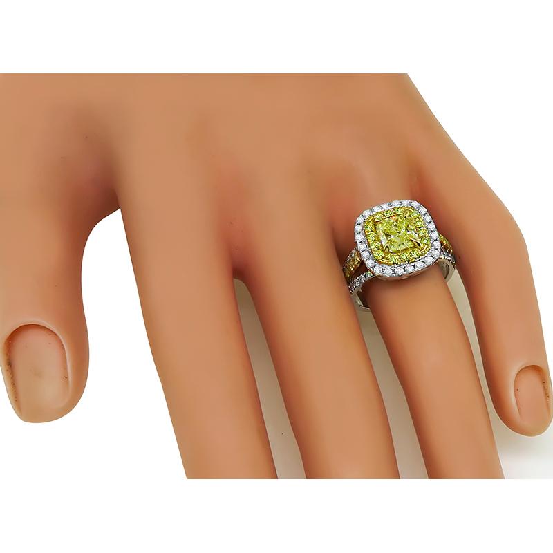 This is a gorgeous 18k yellow and white gold engagement ring. The ring is centered with a sparkling GIA certified cushion cut fancy yellow diamond that weighs 1.51ct. The color grade of the diamond is Intense Yellow with I1 clarity.  The center