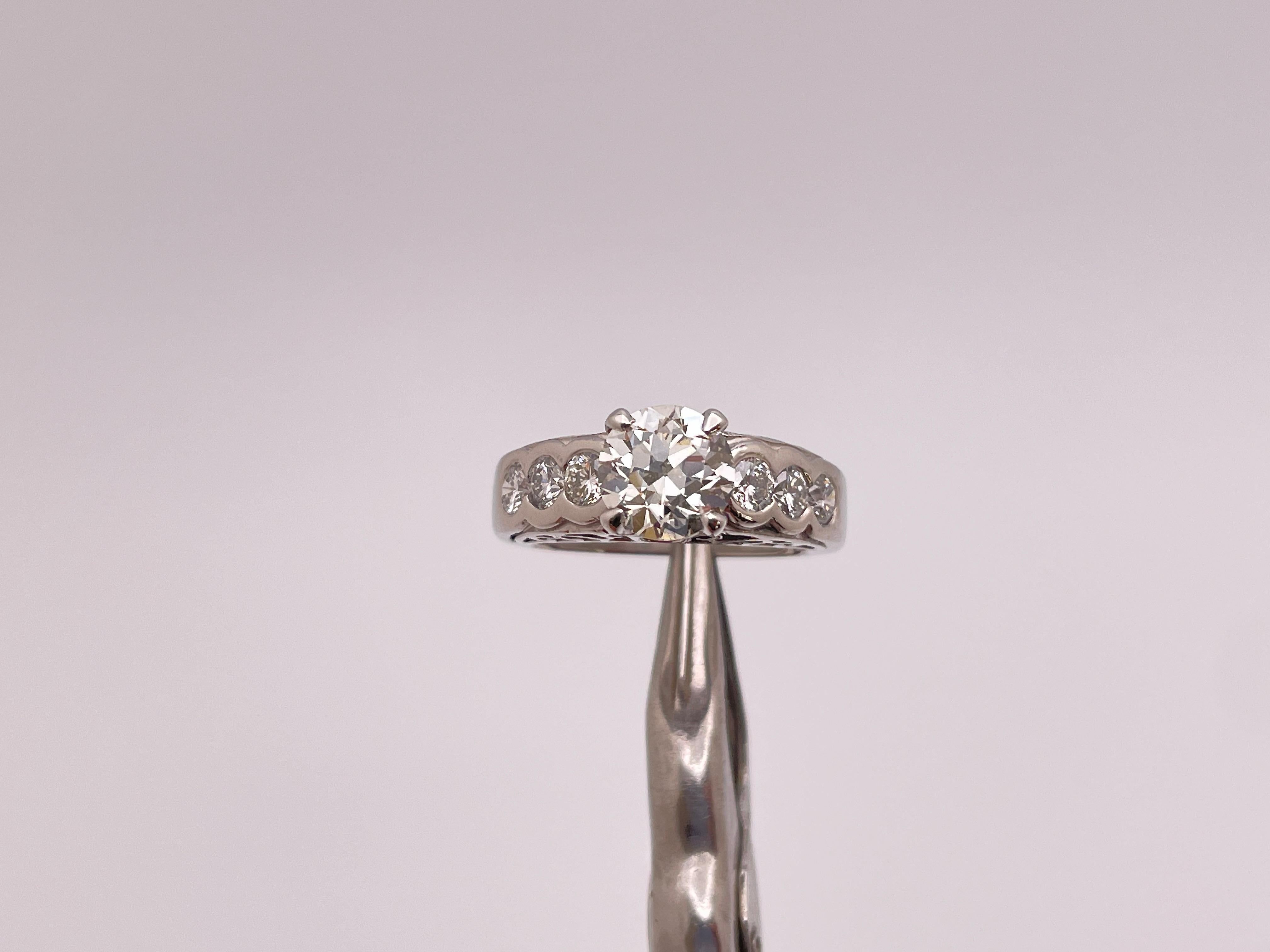 Bague de fiançailles originale en platine et diamant certifiée GIA. Monté avec un diamant rond de taille brillant pesant 1,53 CT, mesurant 7,39 - 7,48 x 4,54 mm, de couleur K et de pureté VS2. Monté avec 6 petits diamants ronds de taille brillant