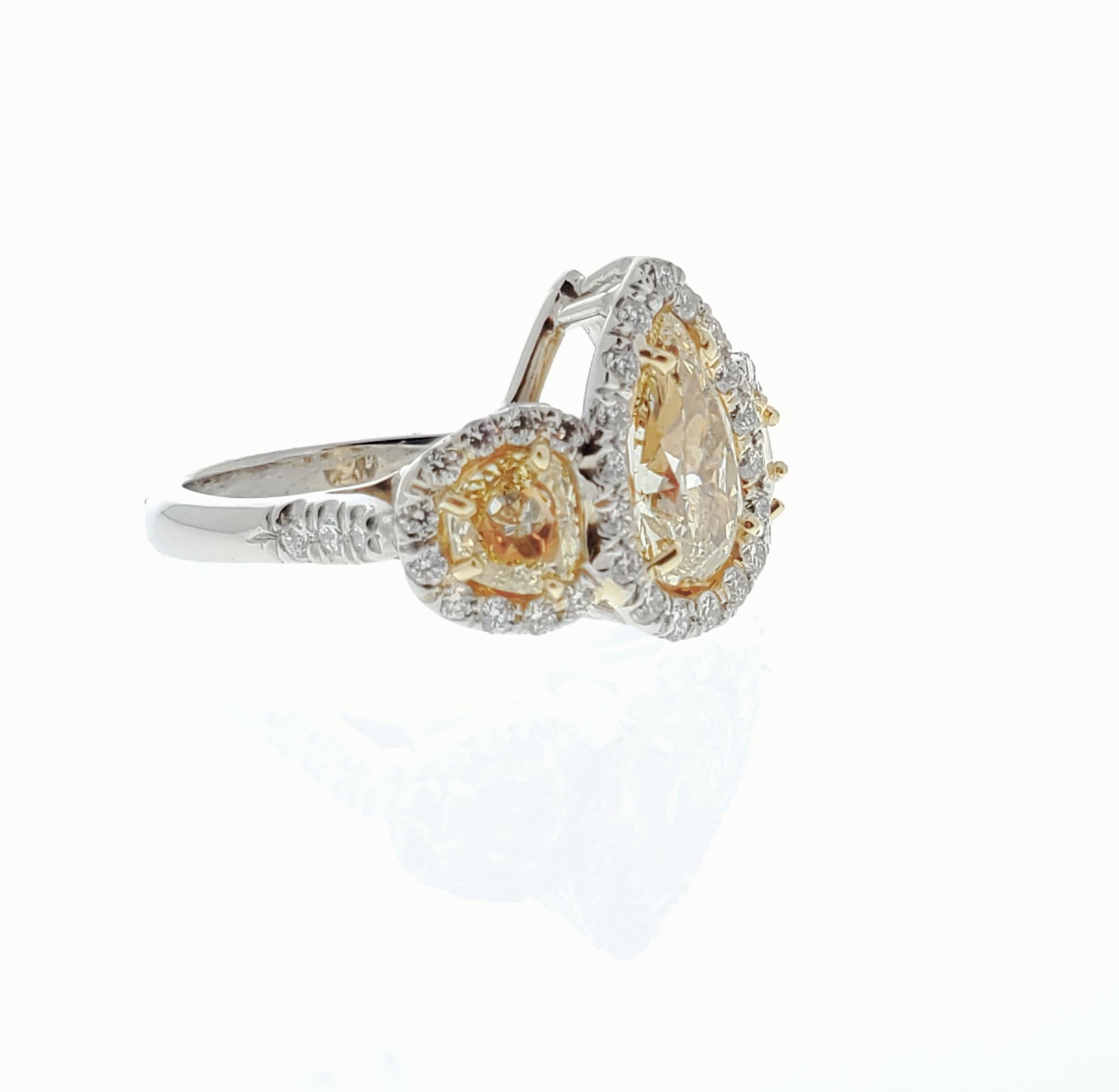 This show-stopping engagement anniversary ring is finely crafted in brightly polished platinum and features a 1.53 carat pear shaped fancy yellow diamond that is accompanied by a GIA certification upon purchase. A total of 0.75 carat fancy yellow