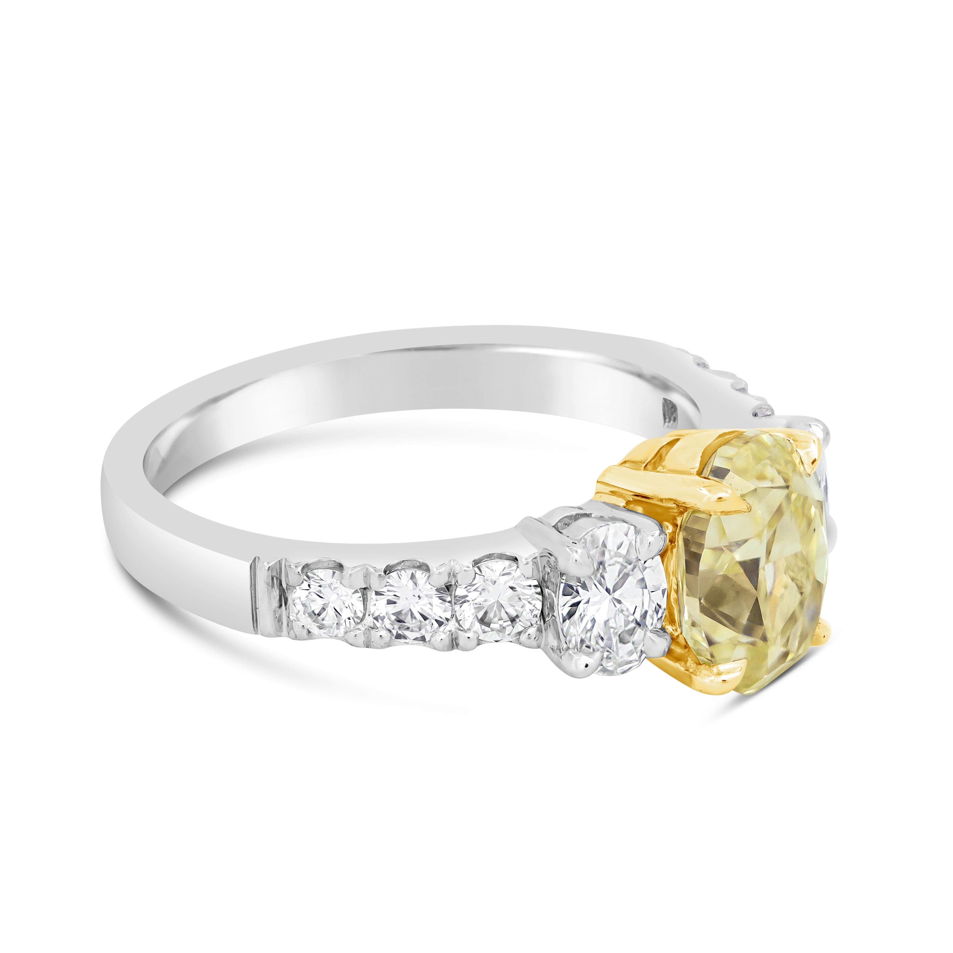 A gorgeous engagement ring, featuring a 1.53 carats oval cut yellow diamond certified by GIA as Fancy Yellow color and VVS2 clarity, set on a four prong setting made of 18K yellow gold. Flanked by two brilliant oval cut diamonds weighing 0.40 carat
