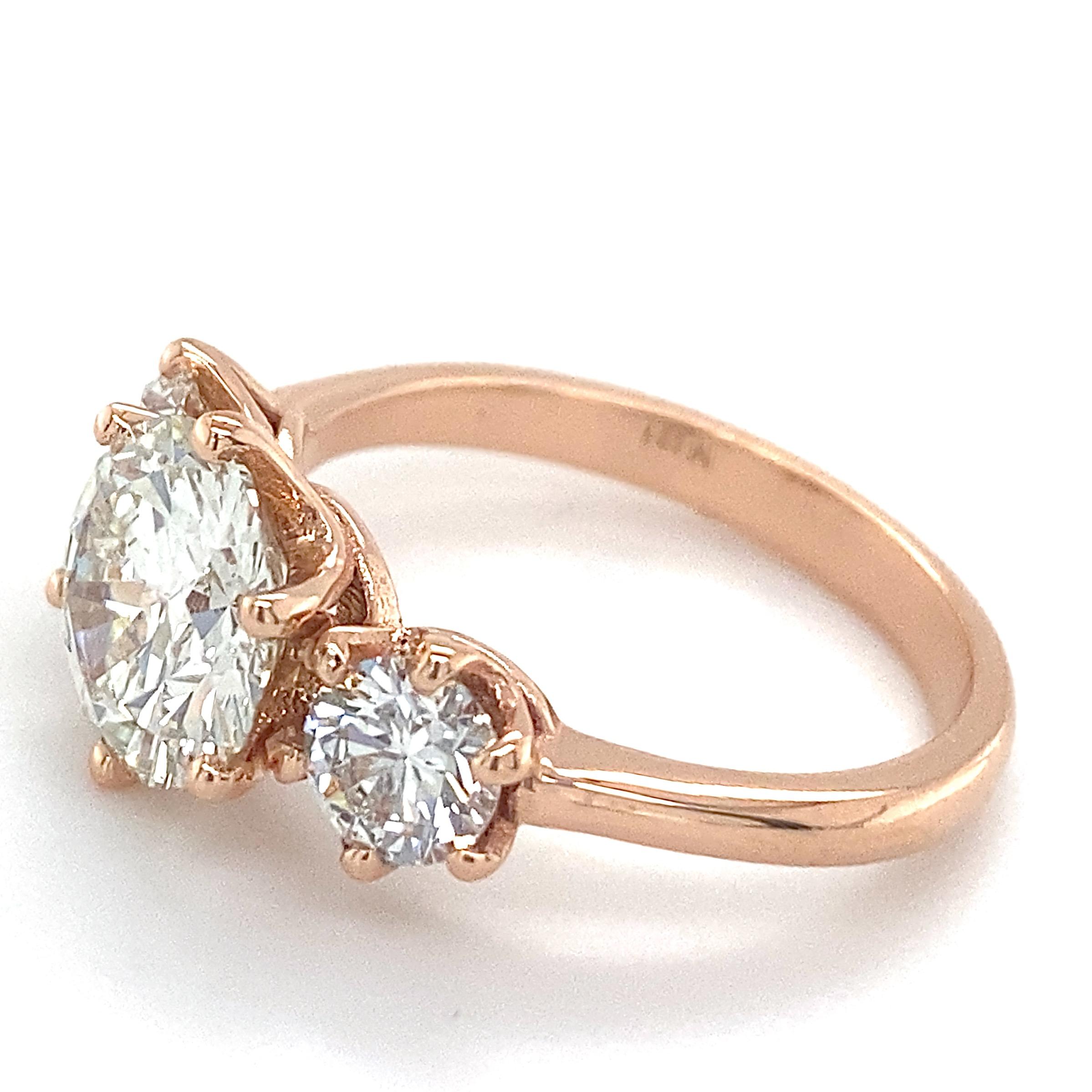 This classic three-stone ring by Eytan Brandes has a distinctive, unexpected edge in vibrant rose gold -- perfect as an engagement or anniversary ring.  

The center stone is a 1.55 carat brilliant cut round.  Included with the ring is a GIA
