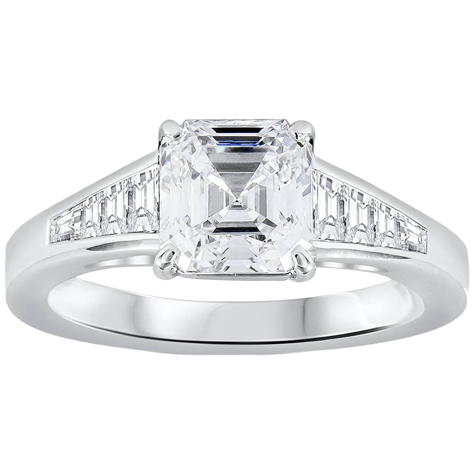 Features a 1.56 carats asscher cut diamond that GIA certified as E color, VS1 in clarity. Flanking the center diamond are 0.40 carats of baguette diamonds channel set in a polished platinum composition. A magnificent piece of jewelry. Size 5.5 US