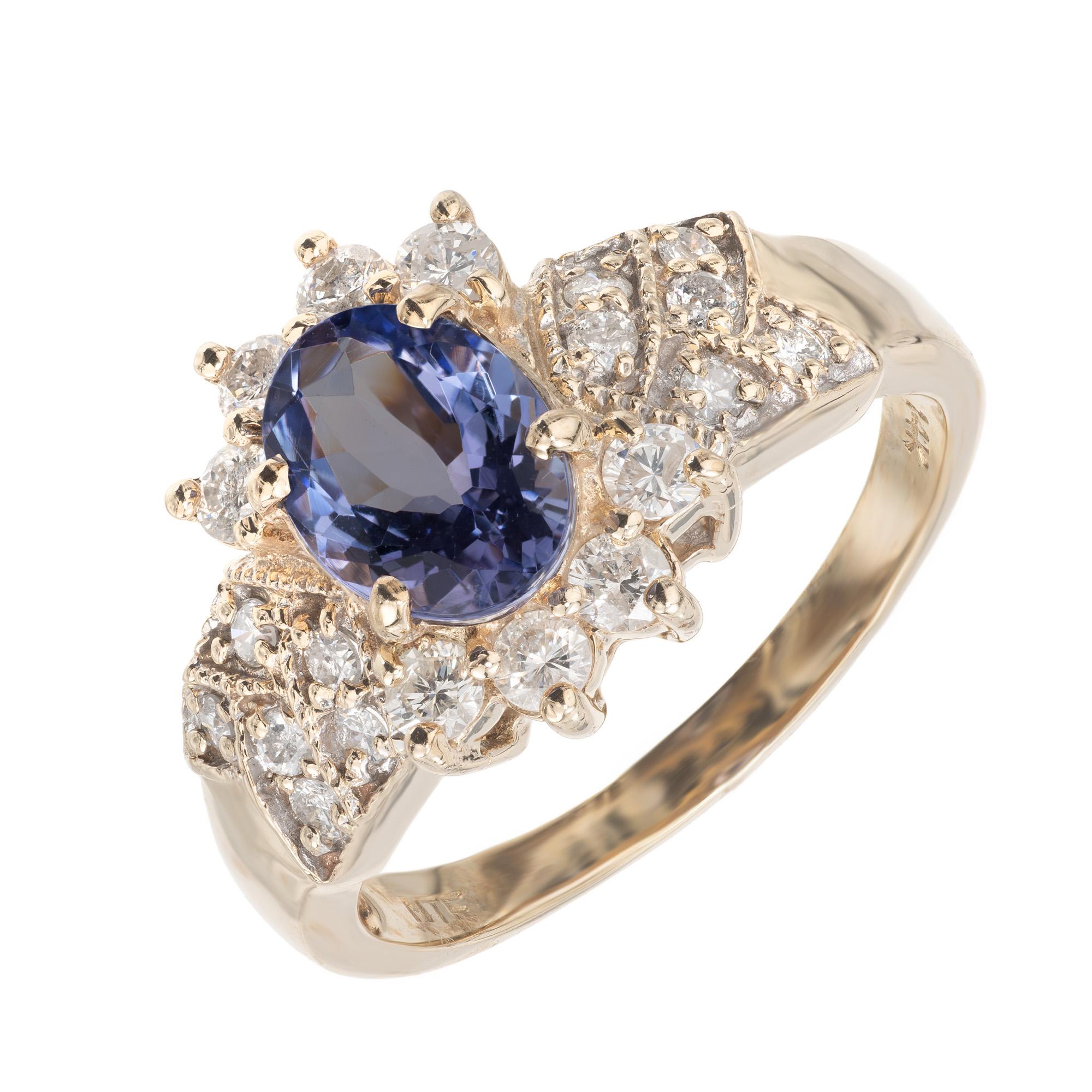  Bague de fiançailles halo en tanzanite et diamant. Tanzanite ovale de couleur bleu violet, sertie en or jaune 14 carats, avec des diamants ronds de taille brillant sertis en épingle en haut et en bas de l'ovale, et des diamants ronds