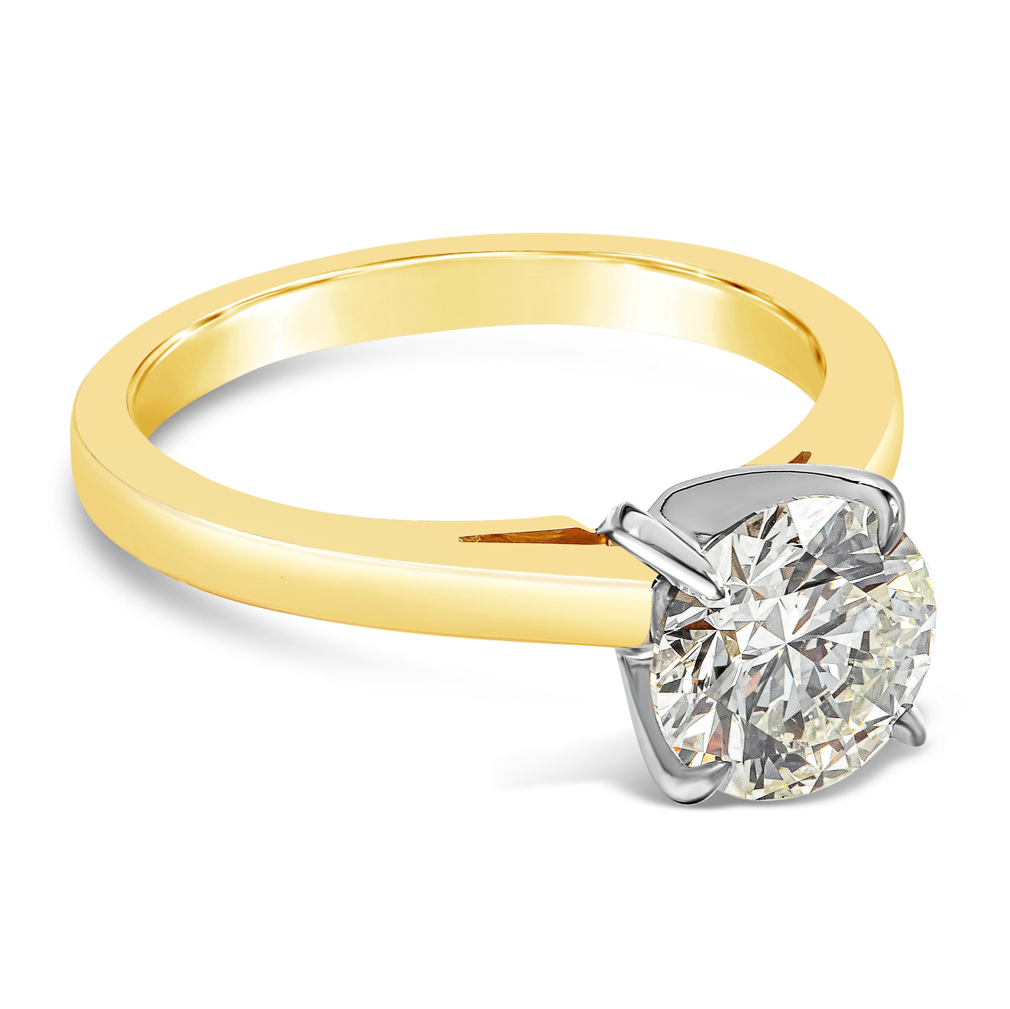A classic and timeless engagement ring showcasing a single round brilliant diamond weighing 1.57 carats total, set in a thin 18K yellow gold mounting and classic 18K white gold four prong setting. GIA certified as N color and SI1 in clarity. Size