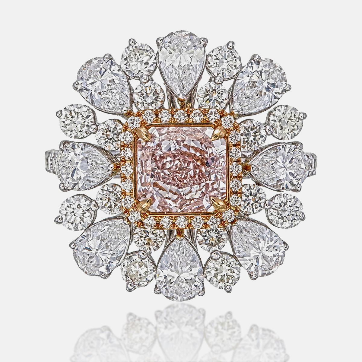 This ring features a 1.59-carat pink diamond as its centerpiece, radiating soft and romantic hues. Surrounding the center stone are 2.05 carats of pear-shaped diamonds and 1.18 carats of round-cut diamonds, creating a nice frame. 

The centre stone