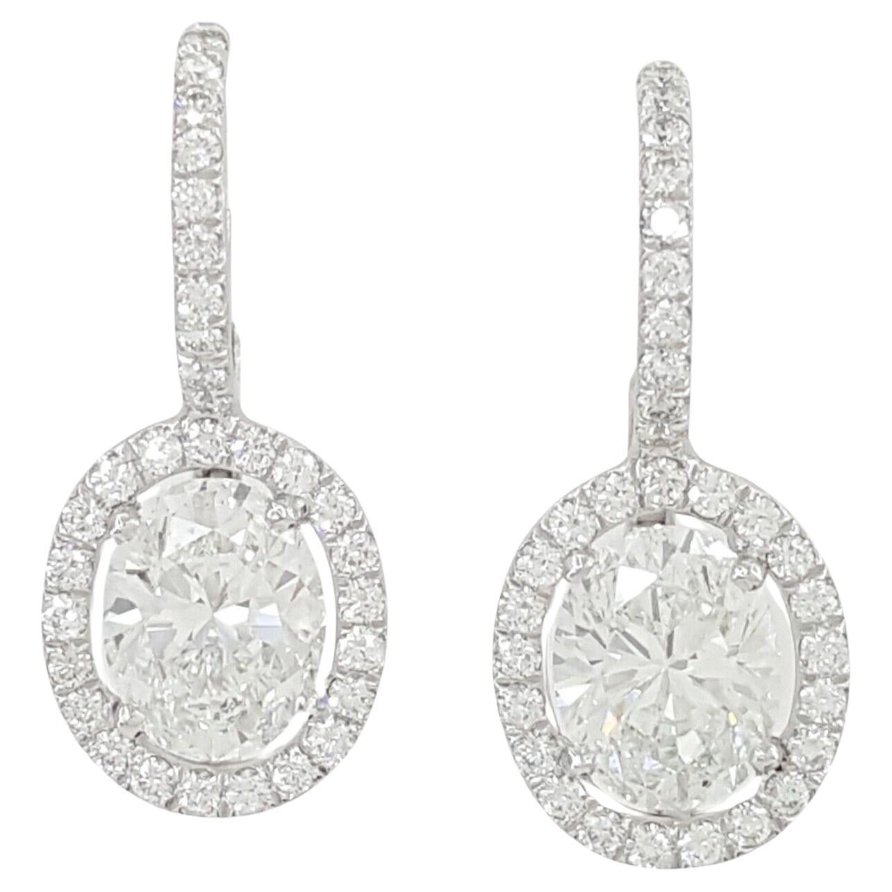 These earrings feature a total weight of 2.66 carats of natural oval brilliant-cut diamonds set in a halo dangle/drop style. The earrings weigh 3.6 grams and comprise two natural oval brilliant-cut diamonds in the center, totaling 2.19 carats with