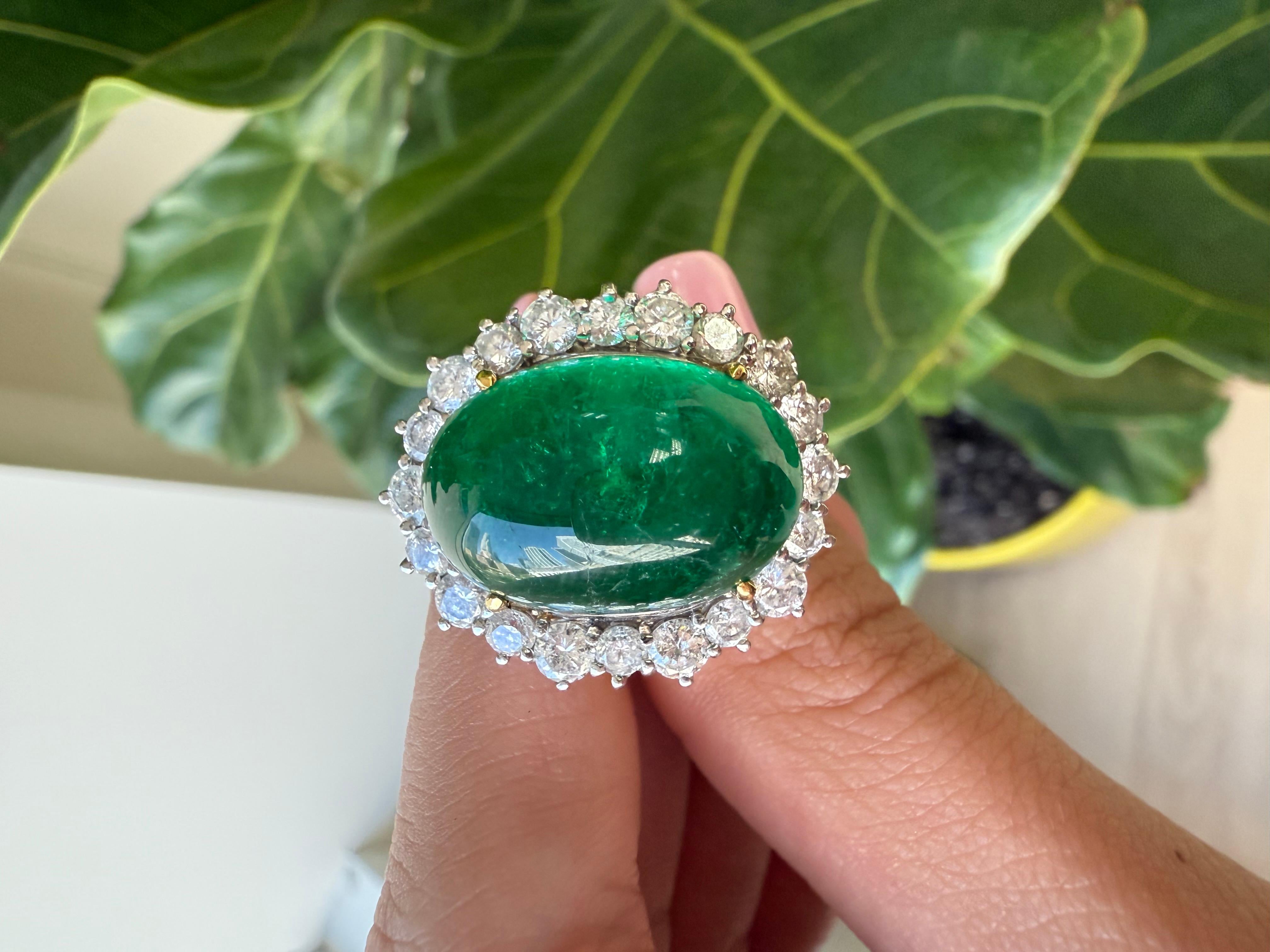 Dieser außergewöhnliche Ring besticht durch einen atemberaubenden, von GIA zertifizierten Smaragd im Cabochon-Schliff von 16,16 Karat, der in einer eleganten Mischmetallfassung aus Platin und Gelbgold gefasst ist. Die leuchtend grüne Farbe und die