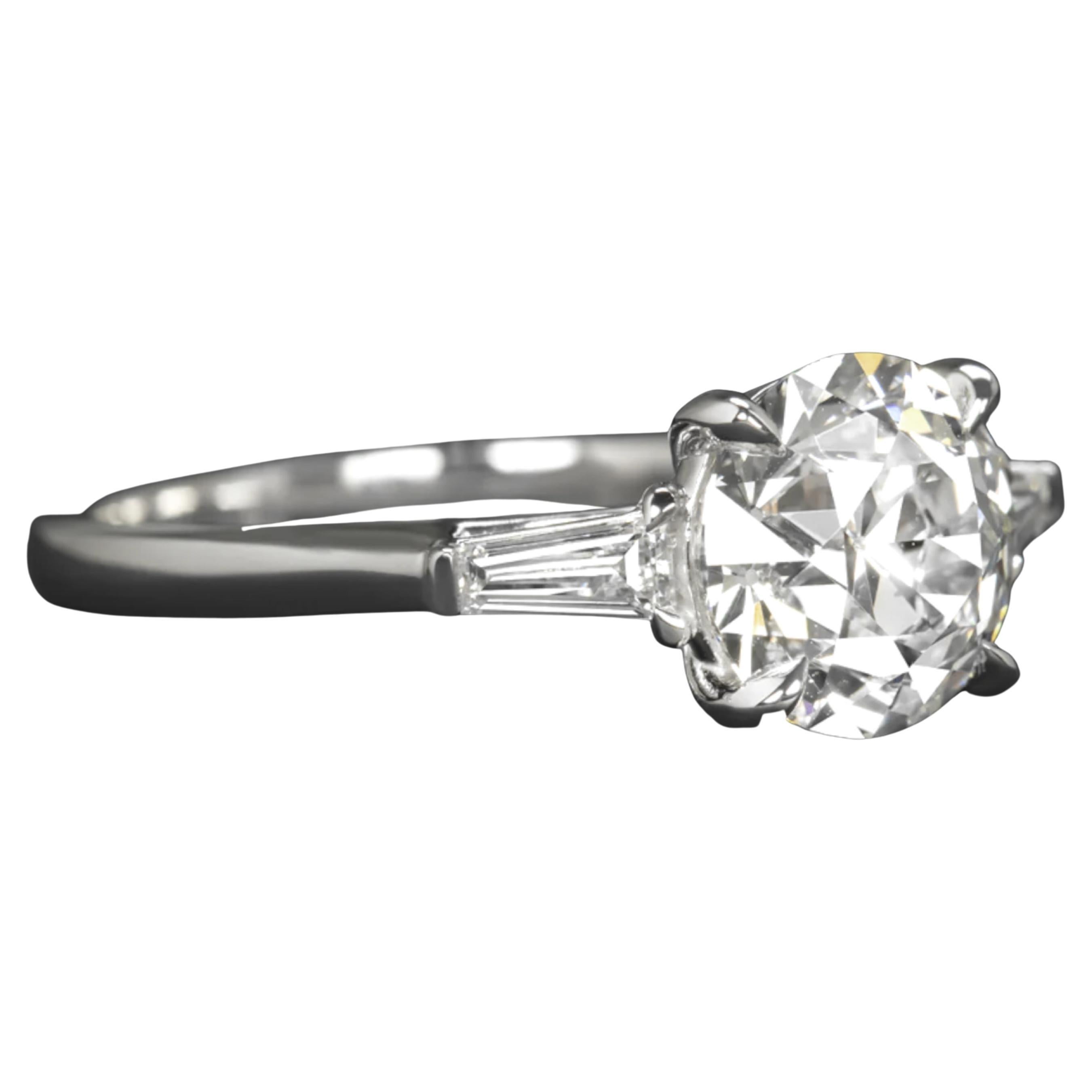 The diamond you described is set in platinum and features tapered baguette side diamonds. It is an original vintage, GIA certified diamond with an impressive size of 1.62 carats, showcasing a gorgeous old mine cut diamond The diamond is 100% eye